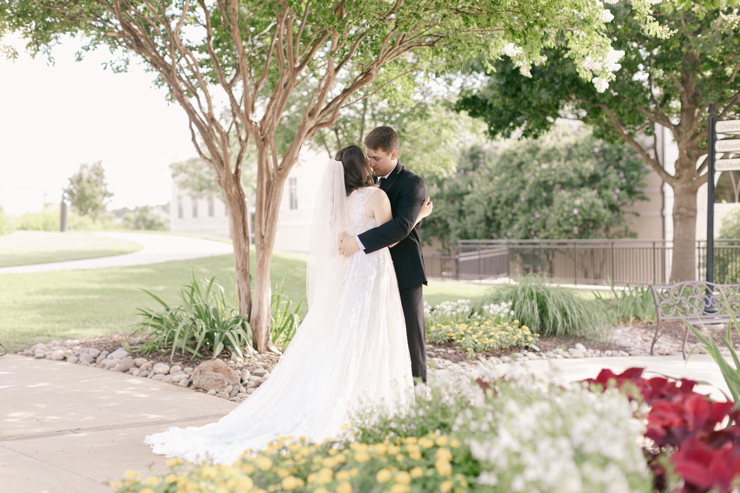 Wedding portraits captured in lush garden setting with stone architecture.