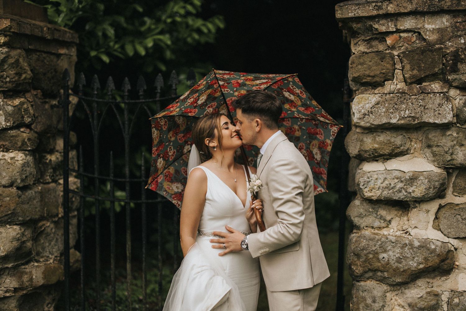 Close-up shot of bride and groom kissing tenderly at a wedding ceremony under an umbrella. Captured by Lincolnshire photographers.