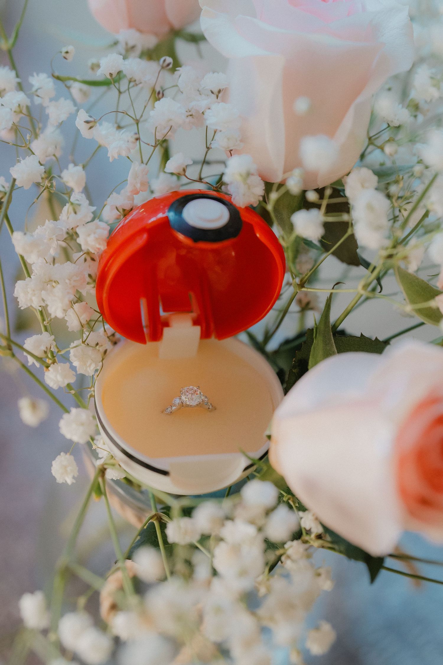 Wedding rings nestled among delicate white baby's breath flowers and soft pink rose petals create a romantic composition.
