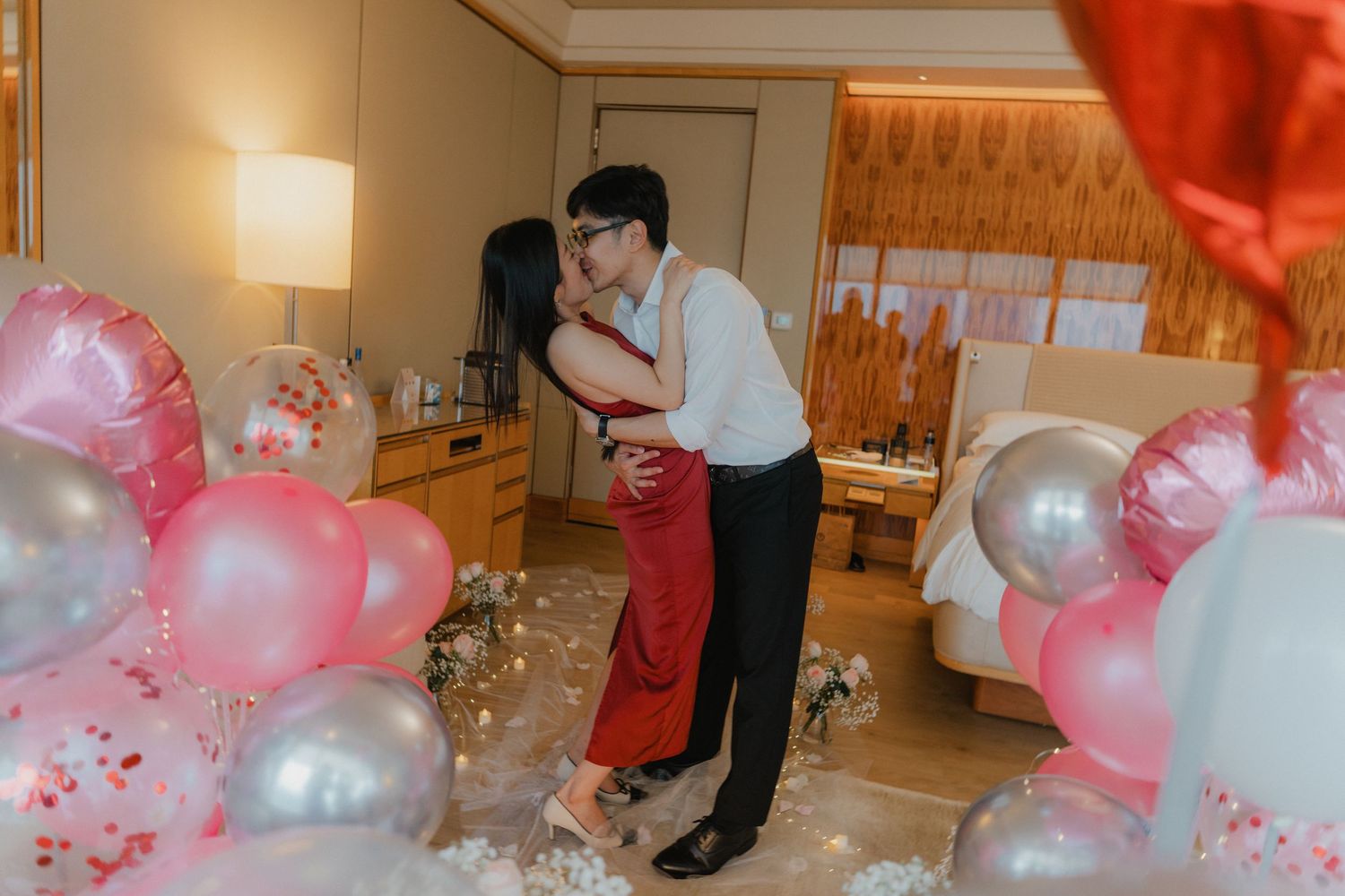 Pink and white balloons fill a beautifully decorated room for a special celebration.
