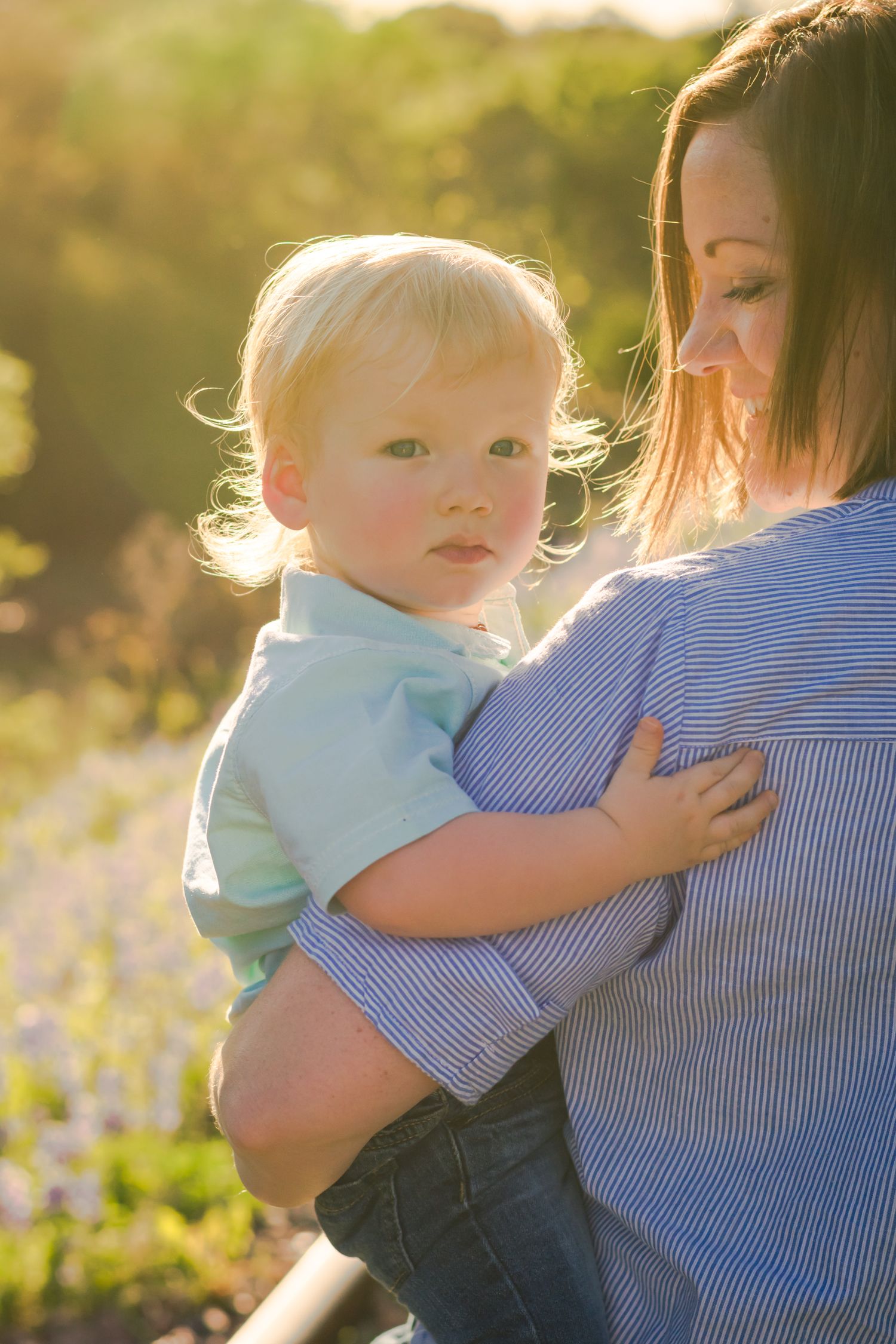 Sweet outdoor portrait series with soft backlighting and spring wildflowers in the background.