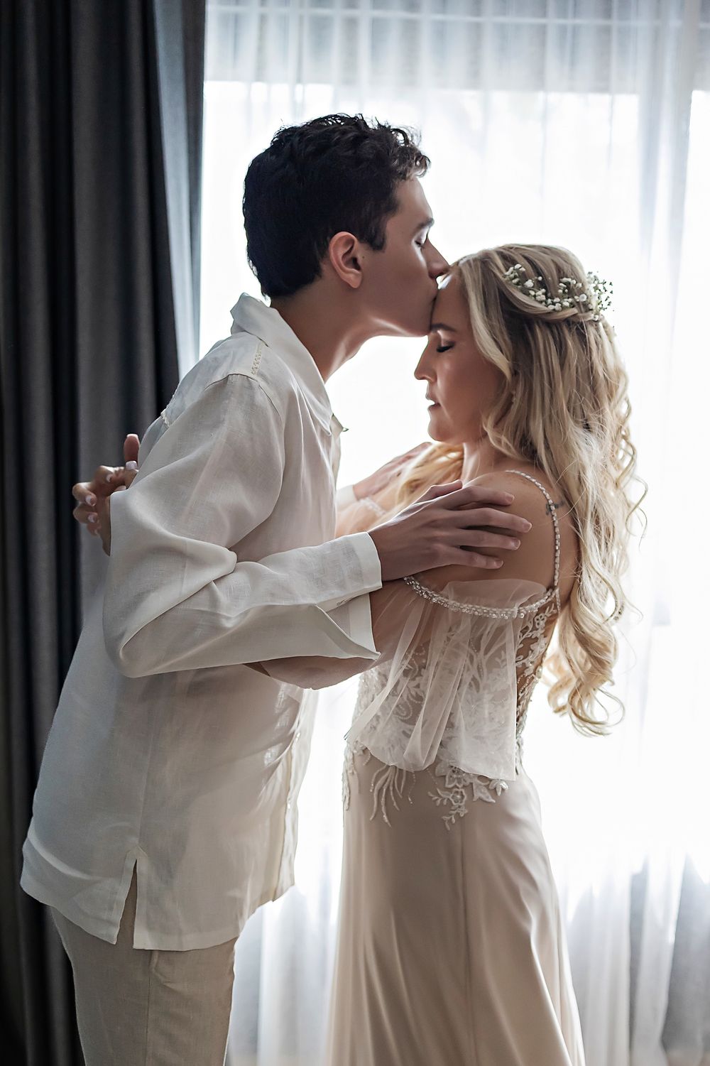 A romantic moment captured in soft light with delicate lace and flowing fabric details.