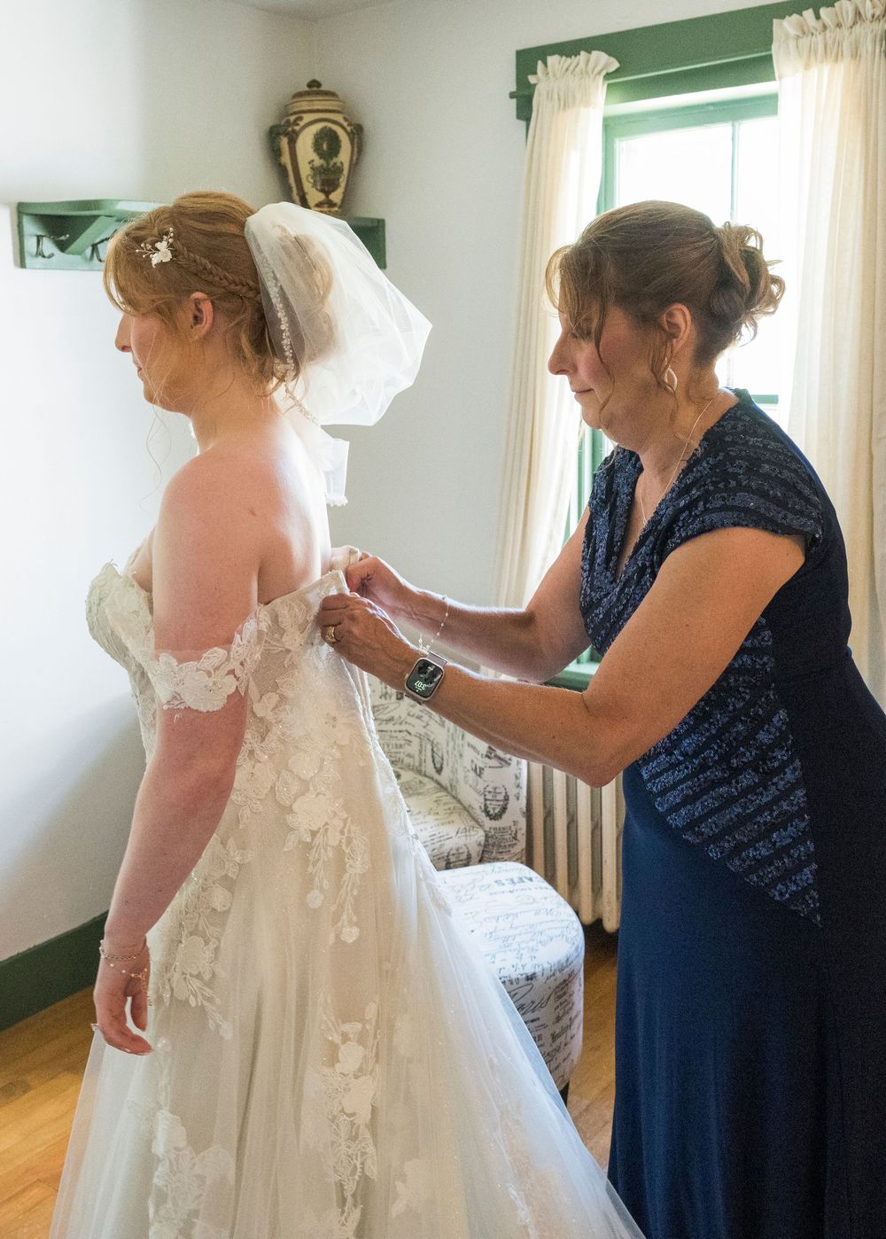 Sequence of getting ready moments showing a wedding dress being buttoned and adjusted in a sunlit room.