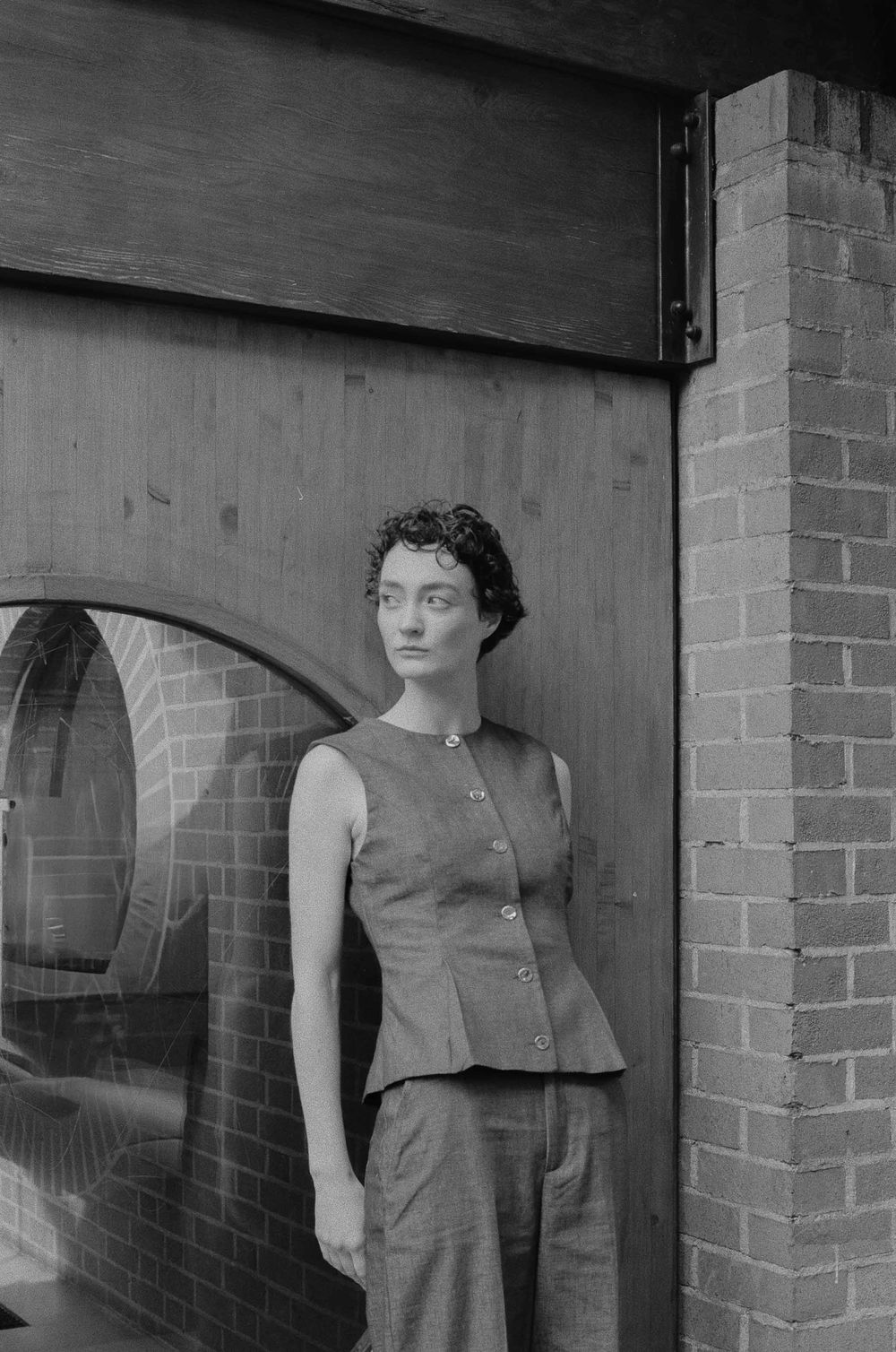 Black and white photographs show wall-mounted fashion displays and brick exterior of a vintage retail establishment.