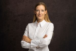 Professional portraits of person in white button-down shirt against dark background.