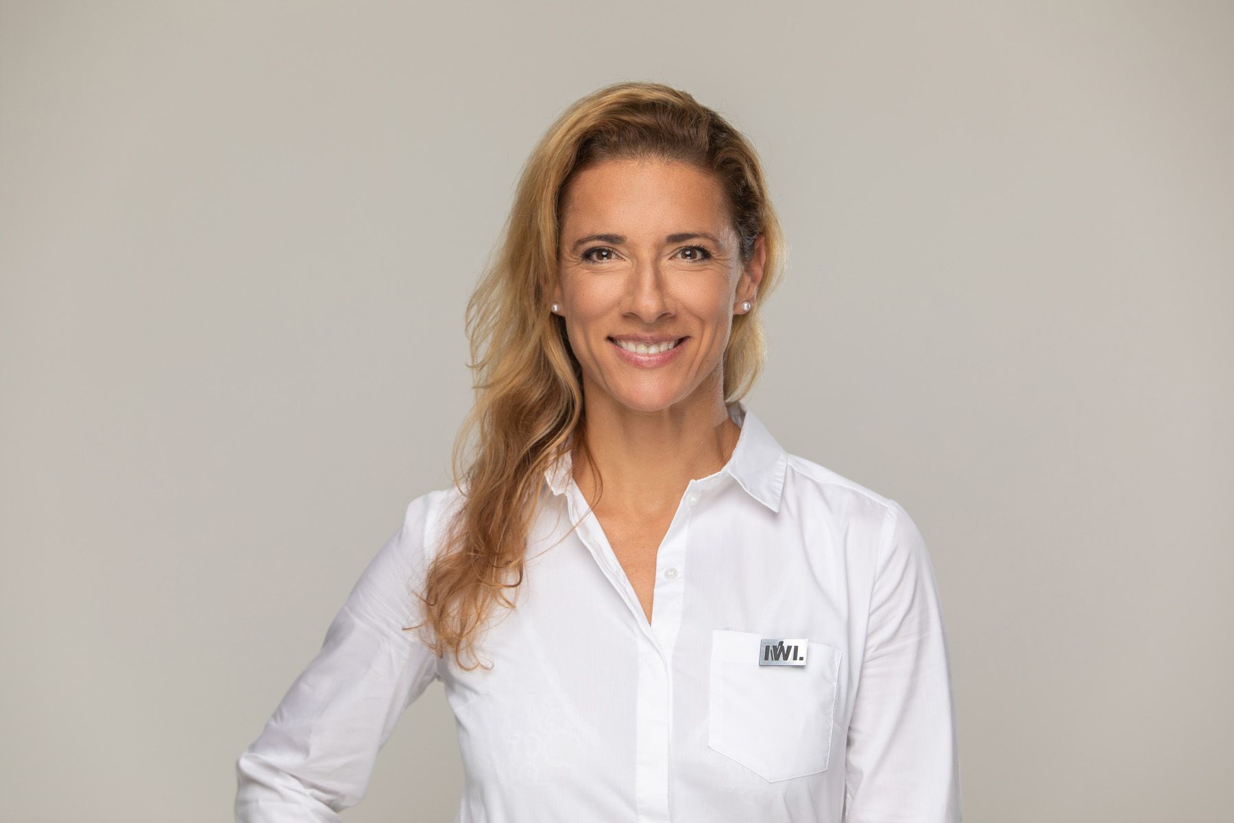 Professional headshot of someone wearing a crisp white button-down shirt against a light gray background.