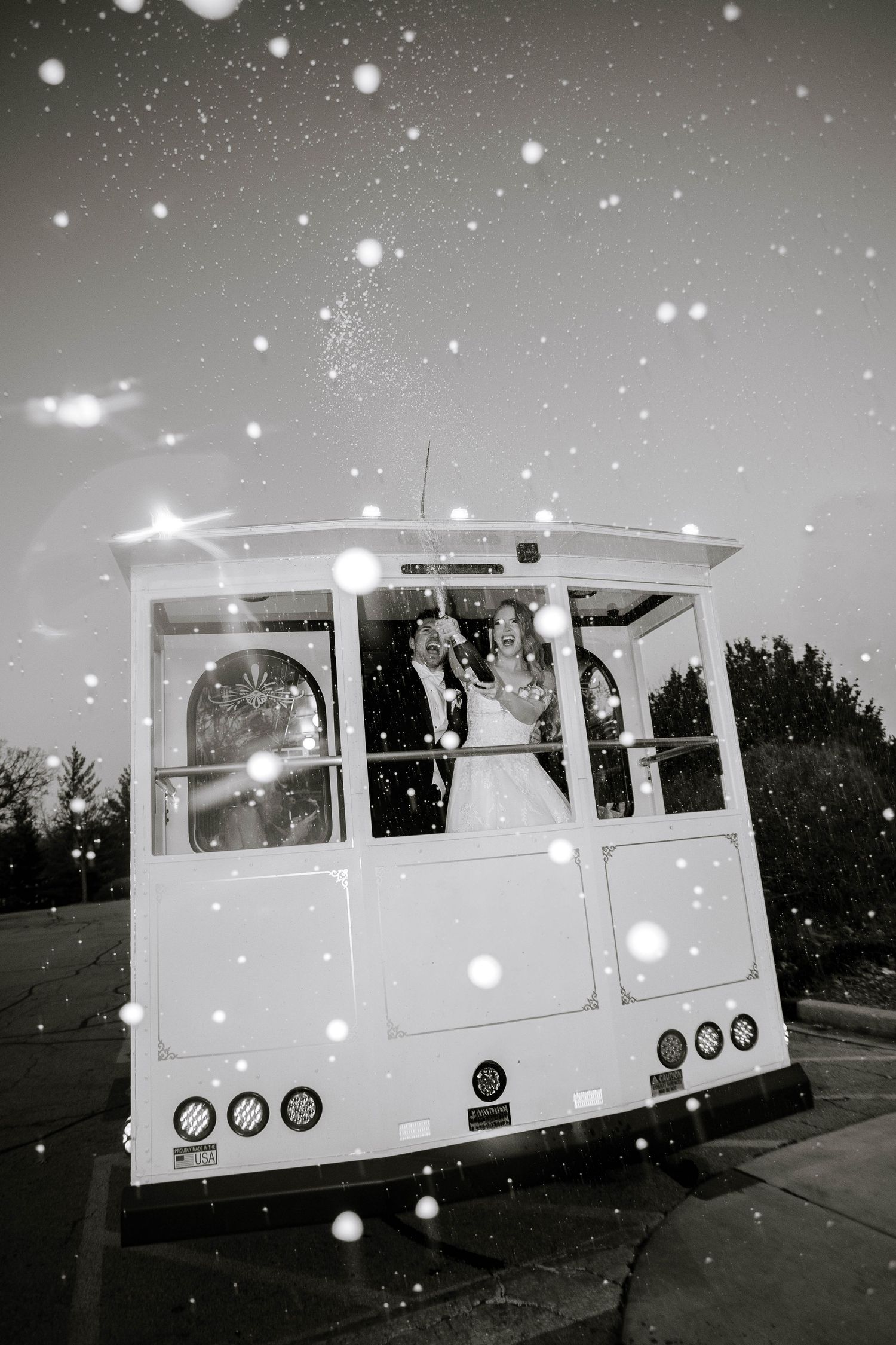 A vintage white caravan trailer shown in a black and white photo sequence with snowfall effect against a dark background.