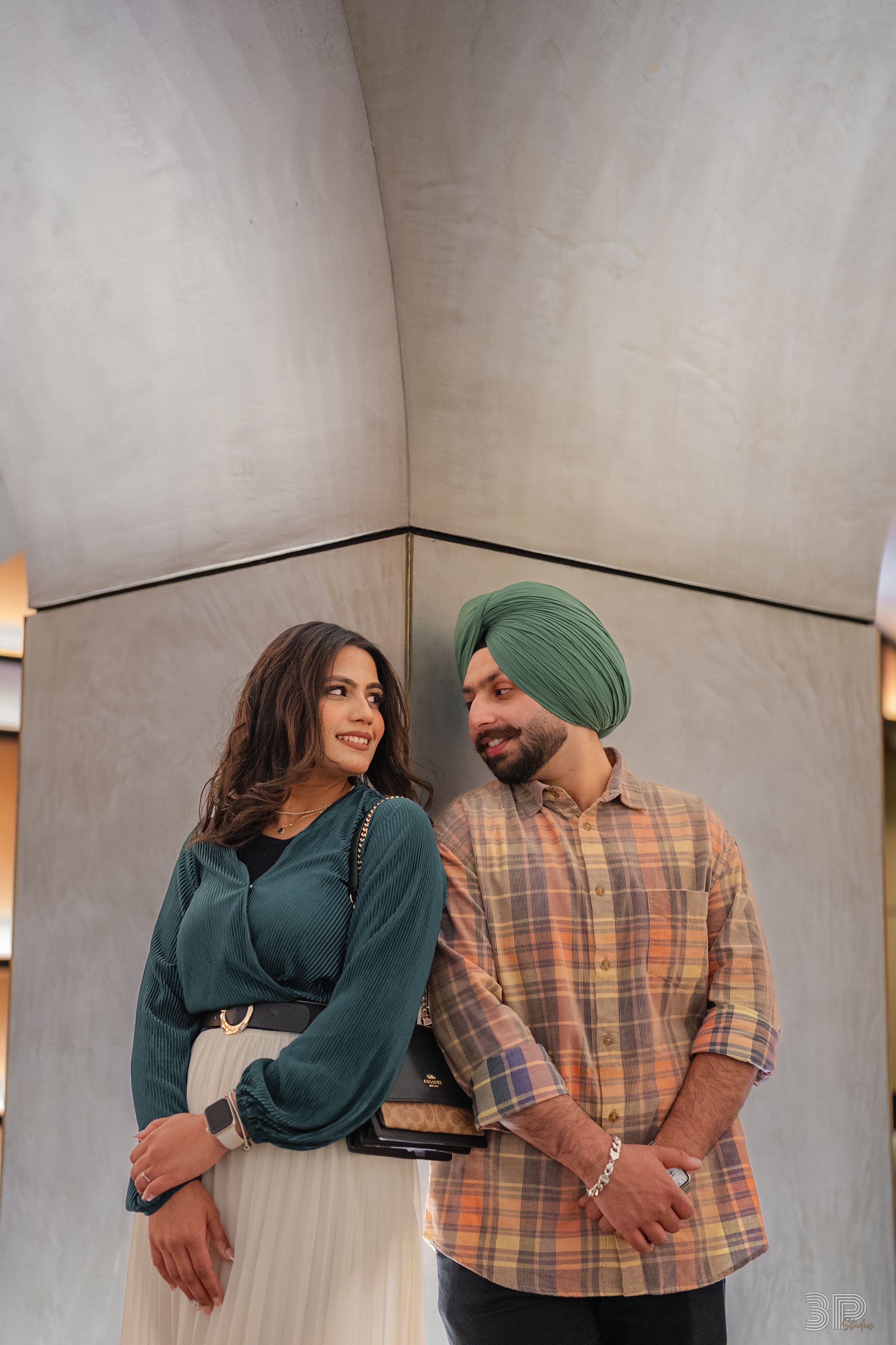 Playful couple in casual attire sharing intimate moments against white studio backdrop in sequence of poses.