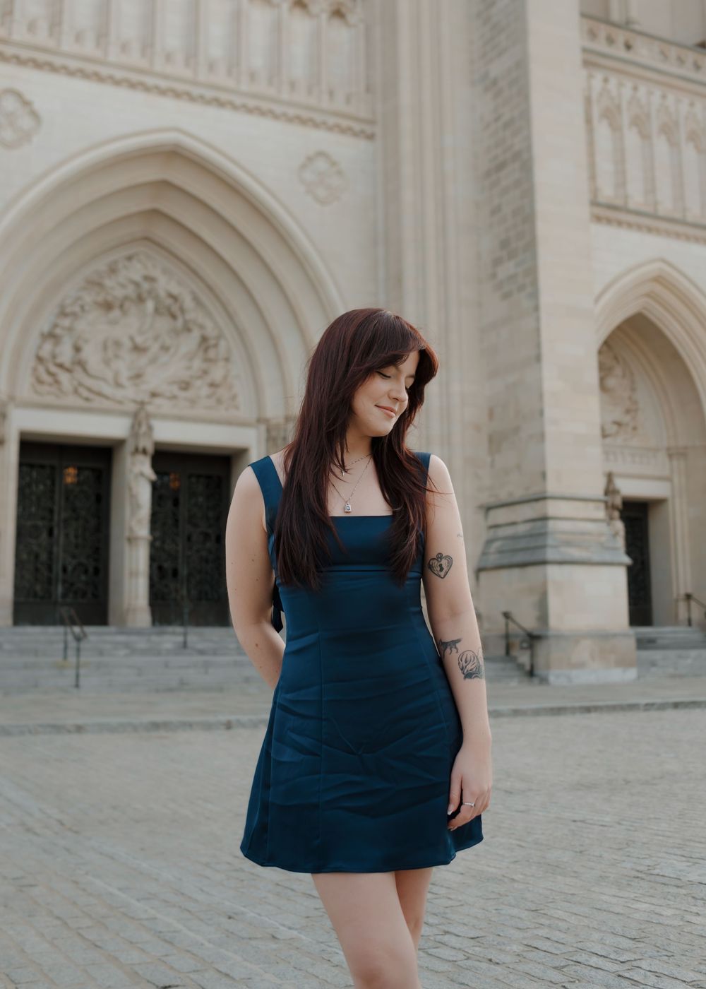 Elegant fashion portrait showcasing a navy dress against ornate gothic cathedral architecture.