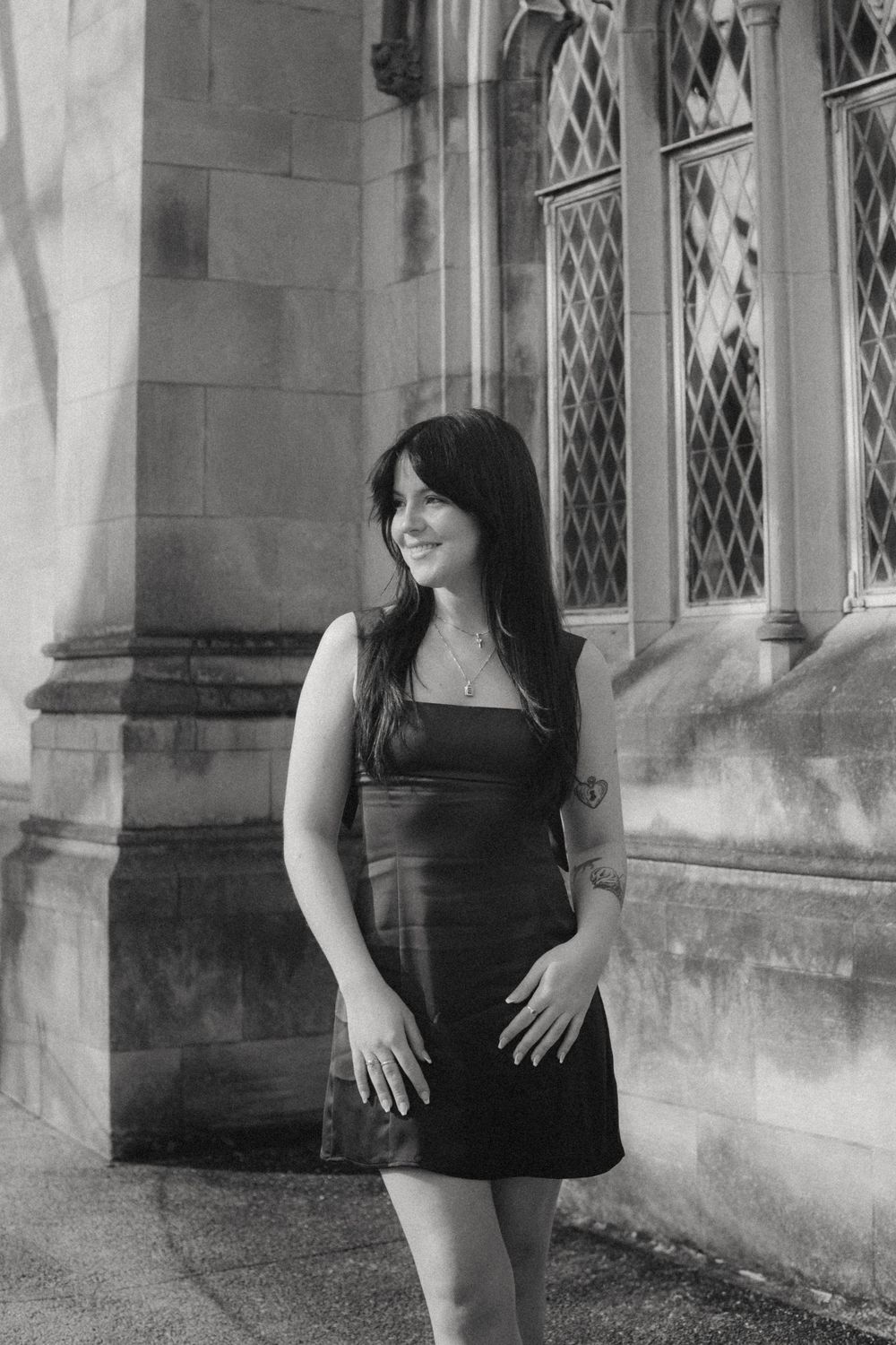 Artistic black and white portraits taken against a stone building with gothic windows.