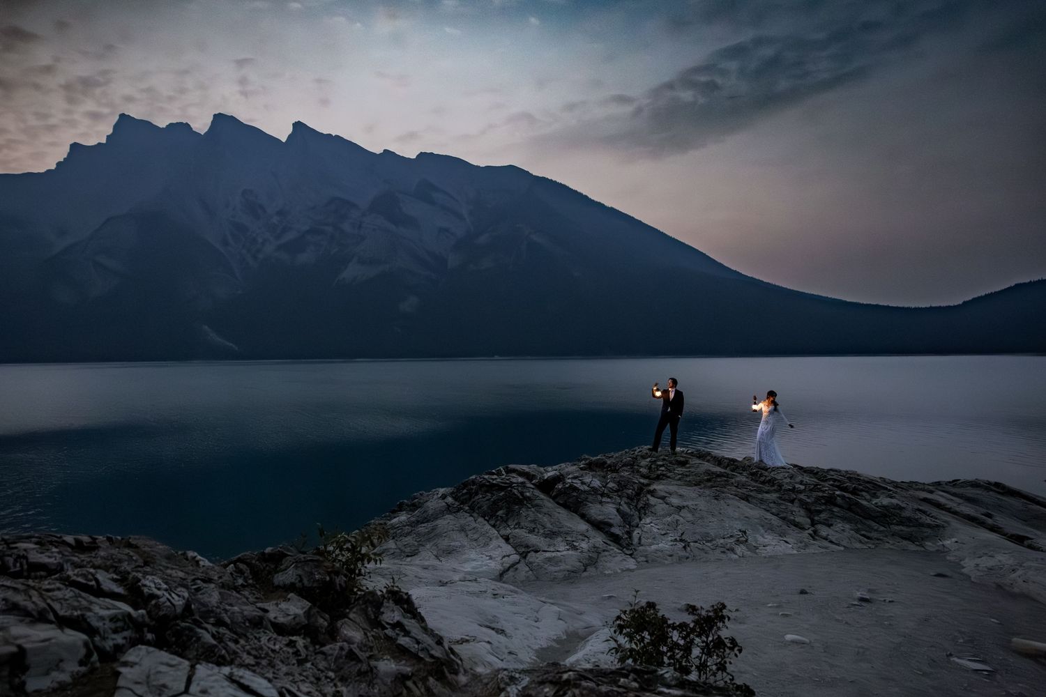 Dramatic mountain landscapes with moody skies and lakes create a stunning panoramic view in the wilderness.
