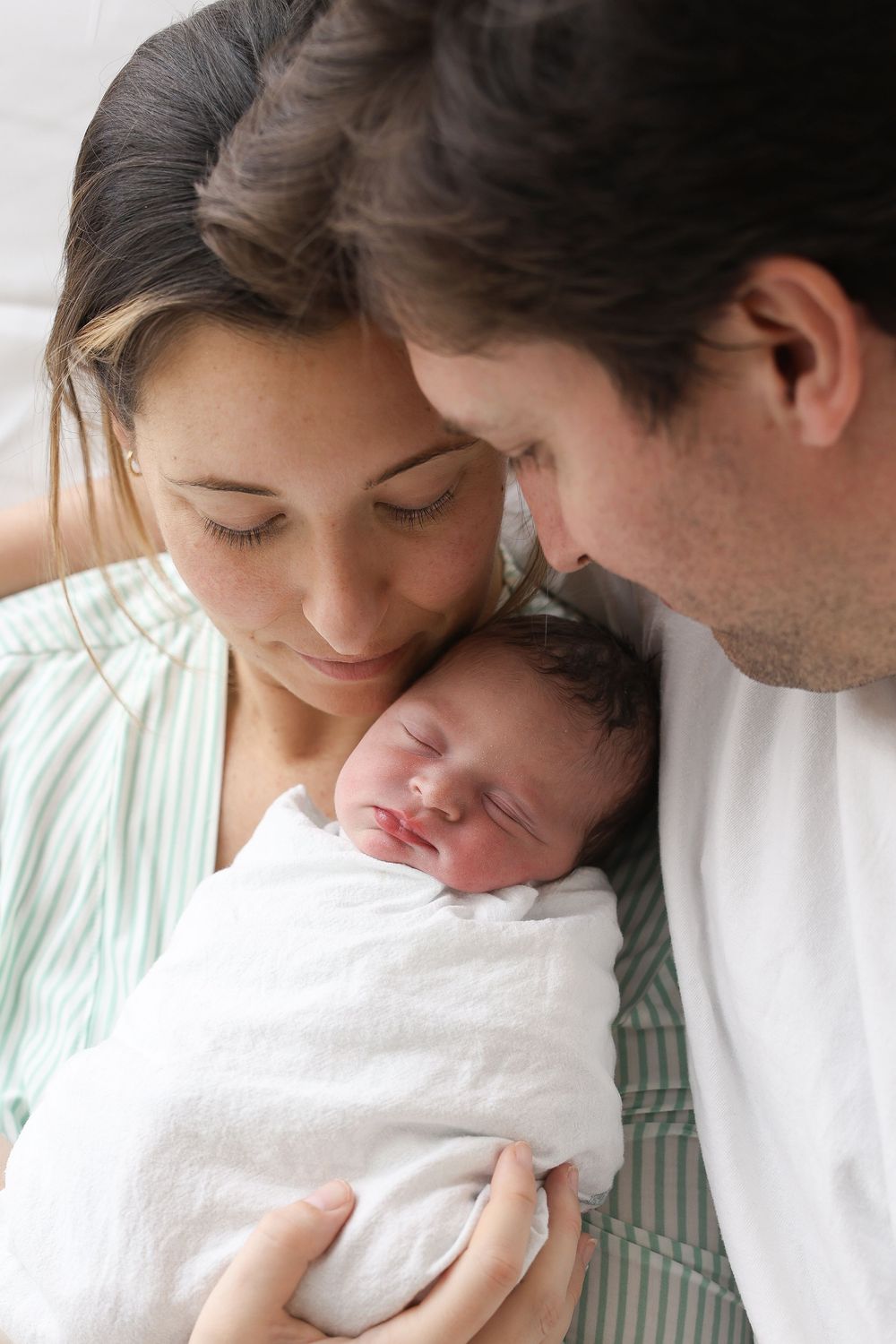 A tender moment between parents and newborn baby shown in four sequential photos.