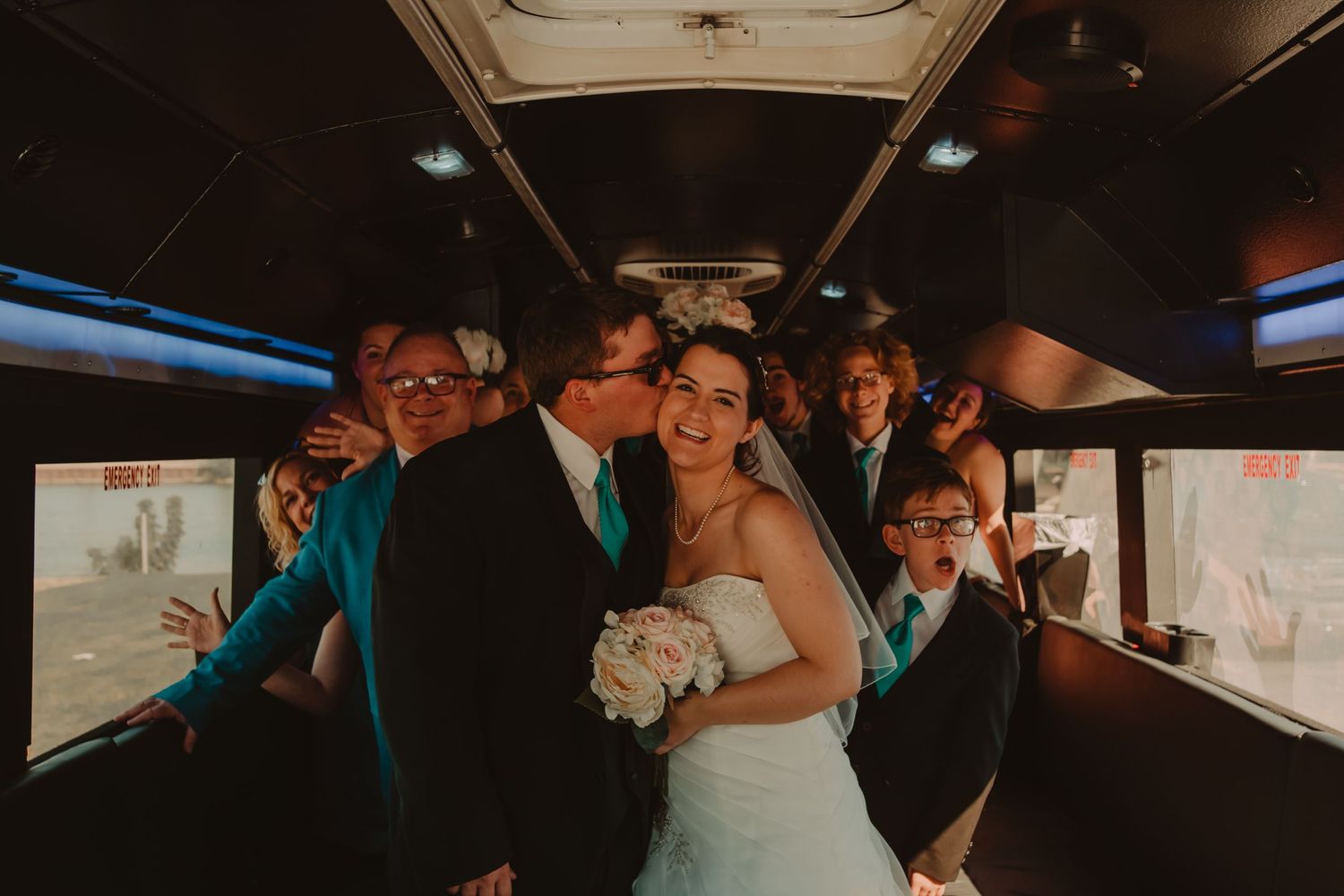 Wedding party celebrates inside a limousine with champagne glasses and festive lighting during an evening celebration.