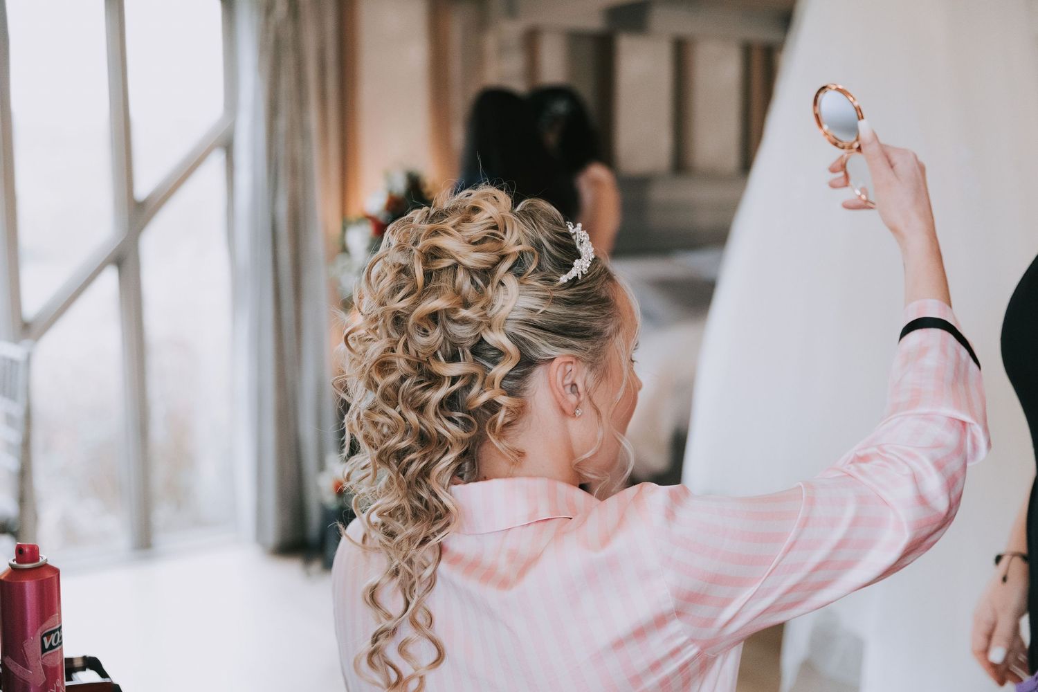 Bride in a blush pink wedding dress twirls and dances joyfully in a bright indoor venue.