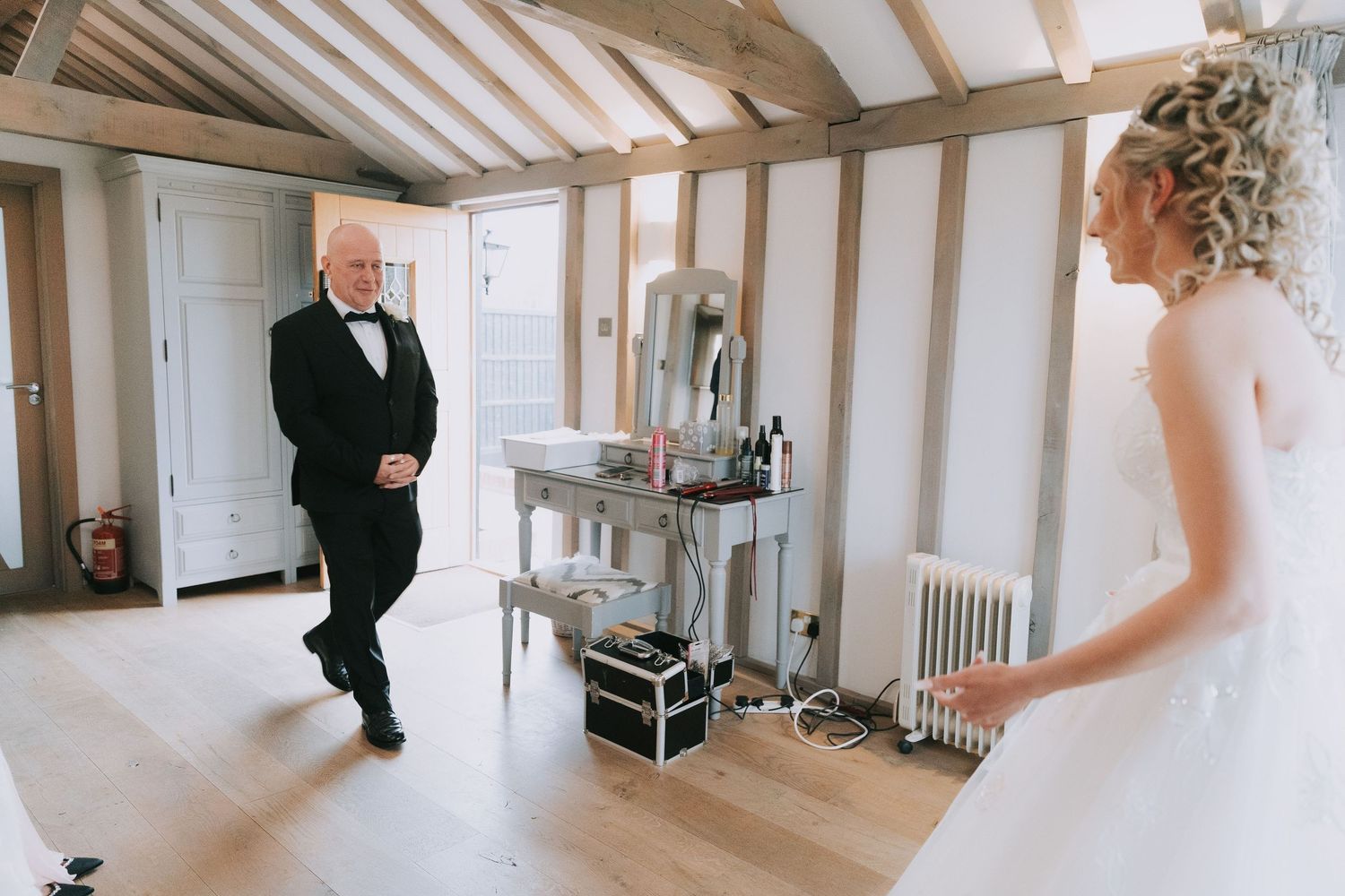 A panoramic view of a bright indoor venue with exposed wooden beams and white walls during a special event.