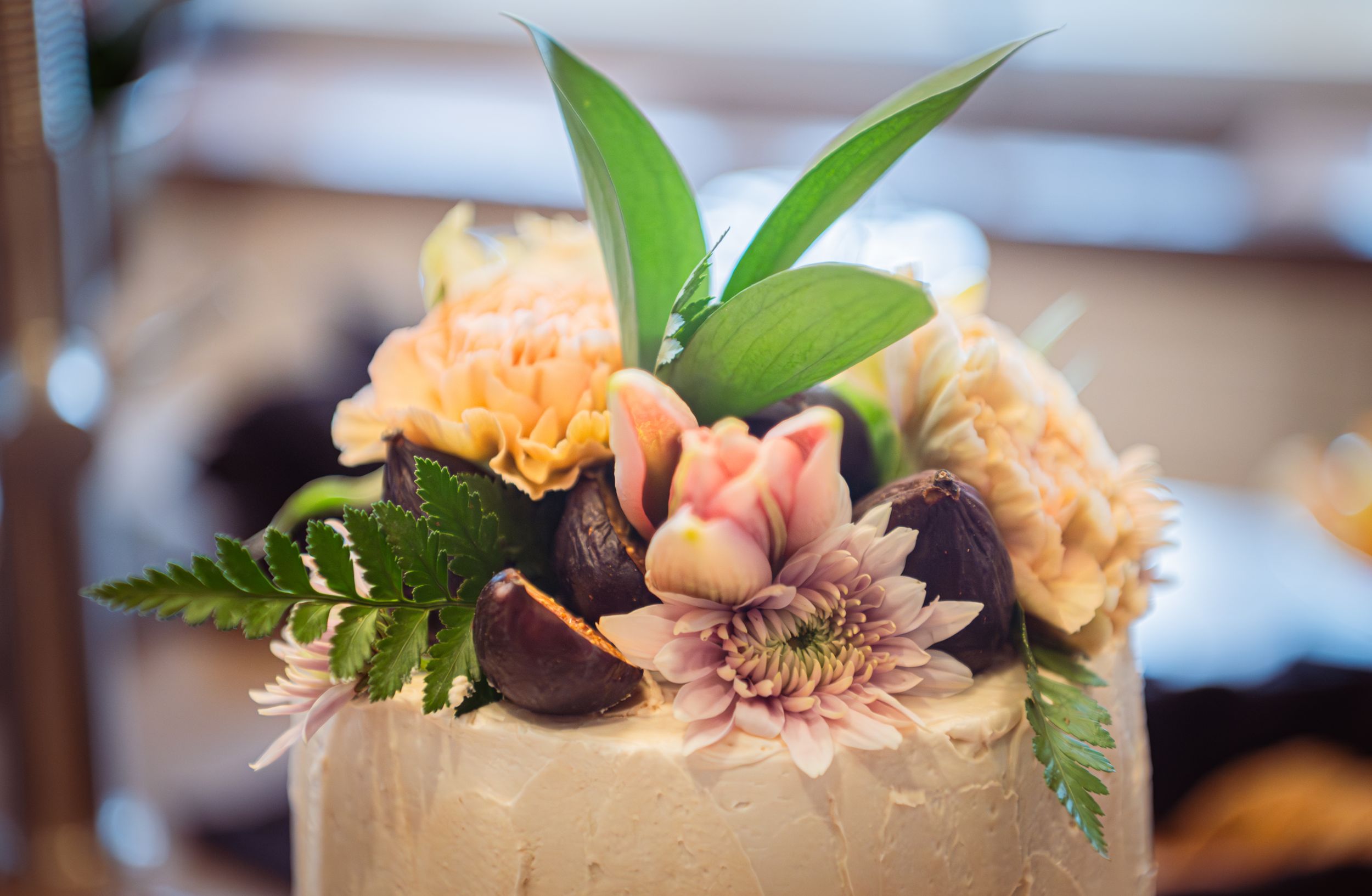 A collection of elegant wedding floral arrangements and desserts displayed on a table at a reception.