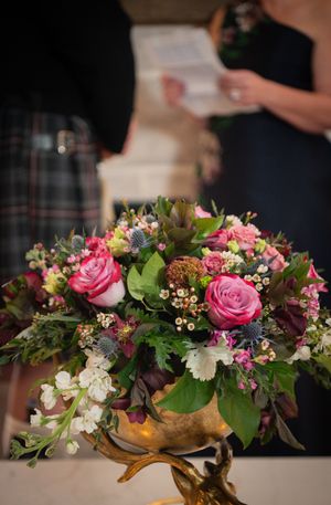 Pink roses and mixed florals arranged in gold vases create an elegant wedding table centerpiece display.