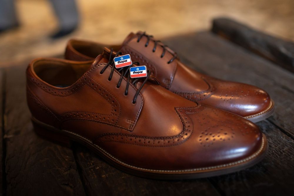 Brown leather dress shoes arranged in a row showing classic brogue detailing.