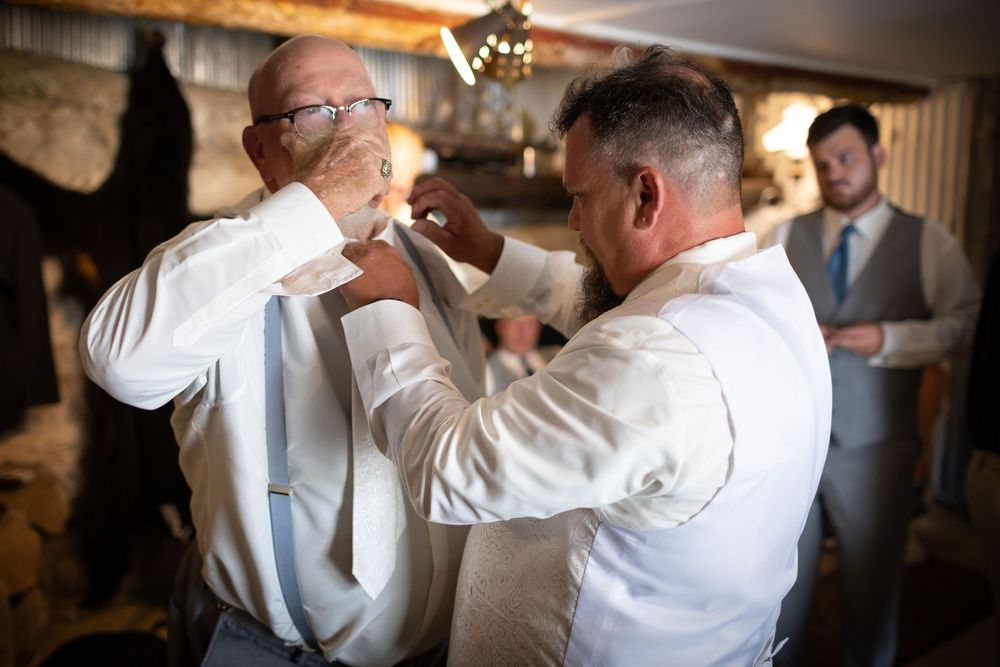Wedding party members toasting and celebrating with drinks at an indoor reception venue.