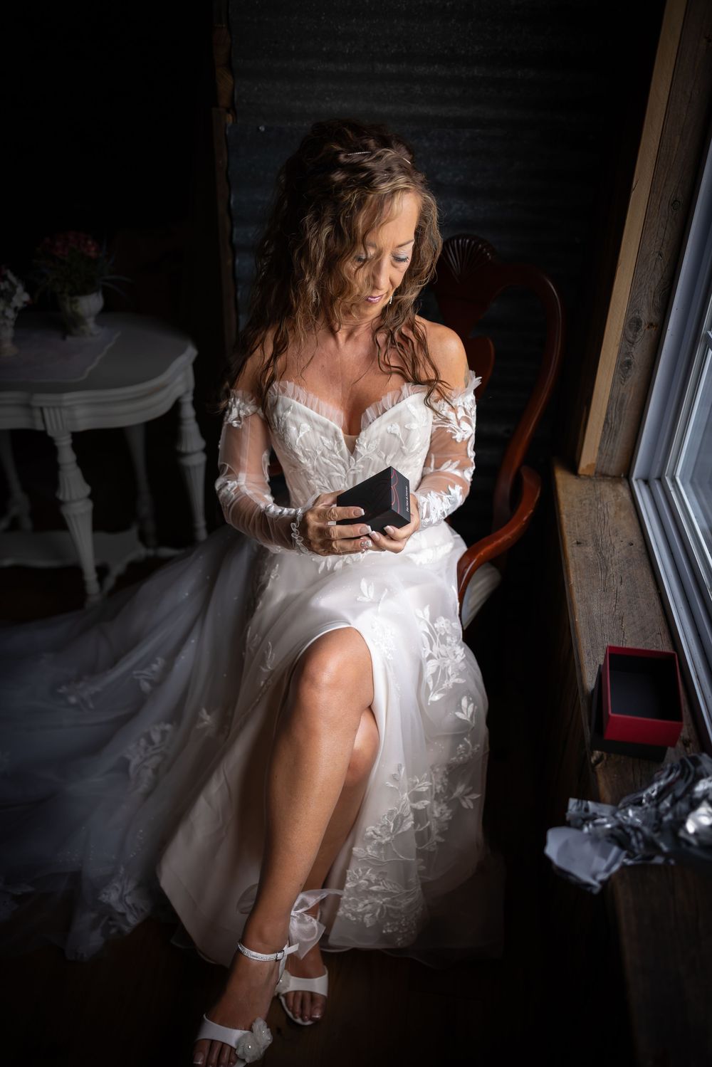 Intimate bridal preparation moments captured in dramatic low-light photography.