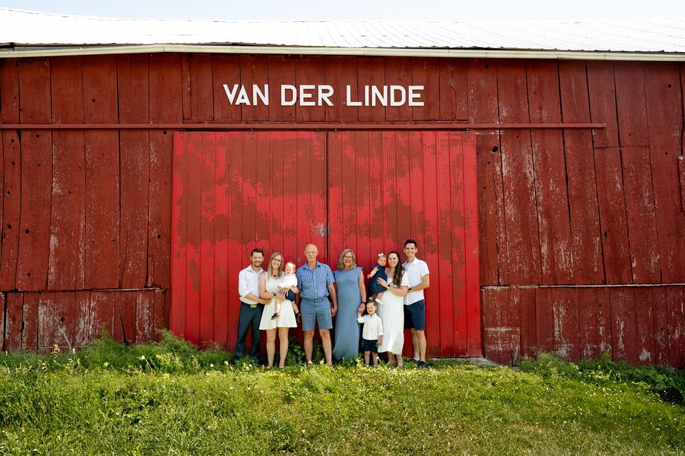 A series of seven photos showing people posing in front of a rustic red barn with 'Van Der Linde' signage.