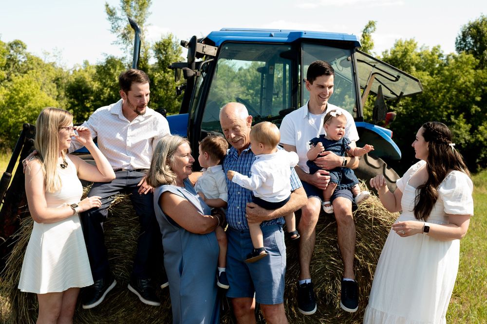 A group of people outdoors celebrate and share joyful moments during a special event in a garden setting.