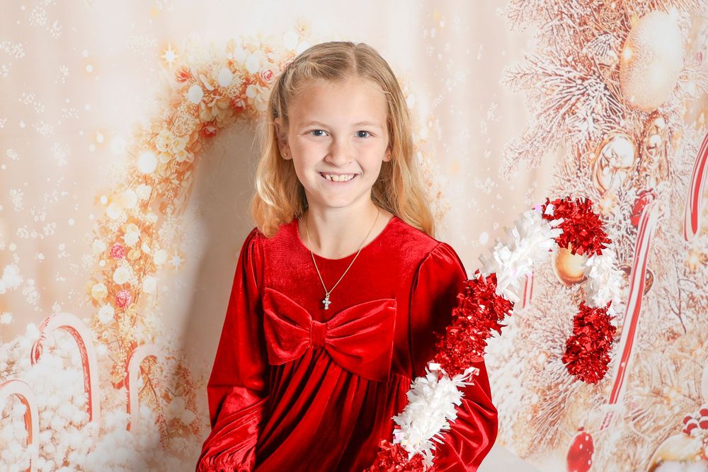 Holiday photo setup with red and white decorations against sparkly background.