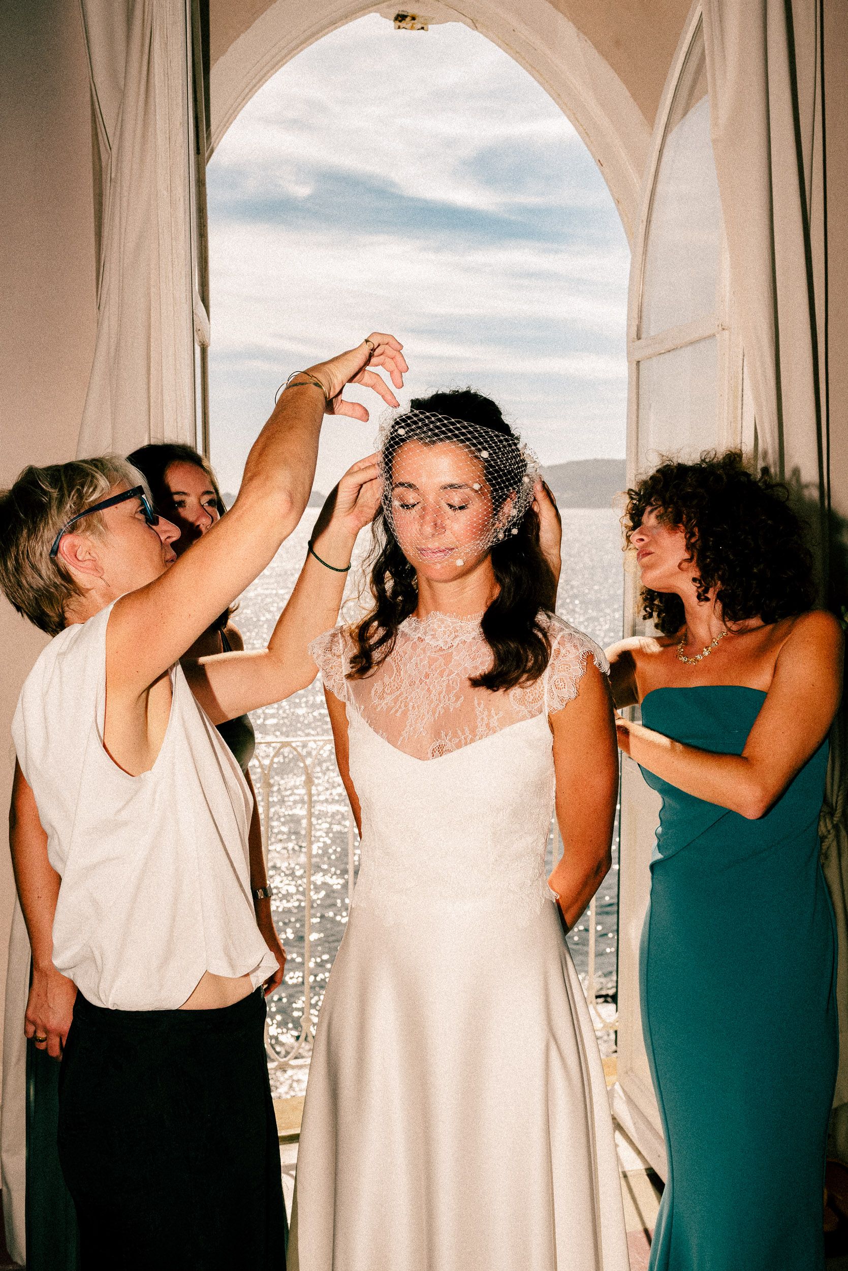 A series of photos showing bridesmaids in green dresses and white dresses posing dramatically by windows.