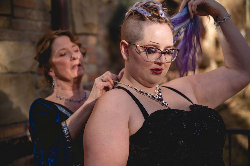 Two performers in formal evening wear pose dramatically during a theatrical performance.