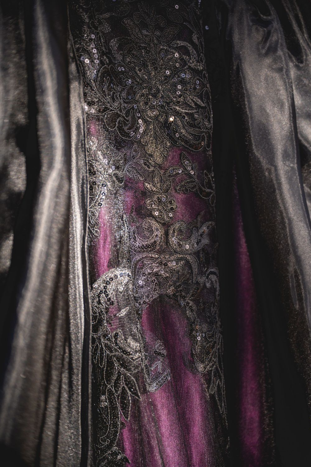 Abstract black and silver metallic texture with pink accents creating a moody atmospheric pattern.