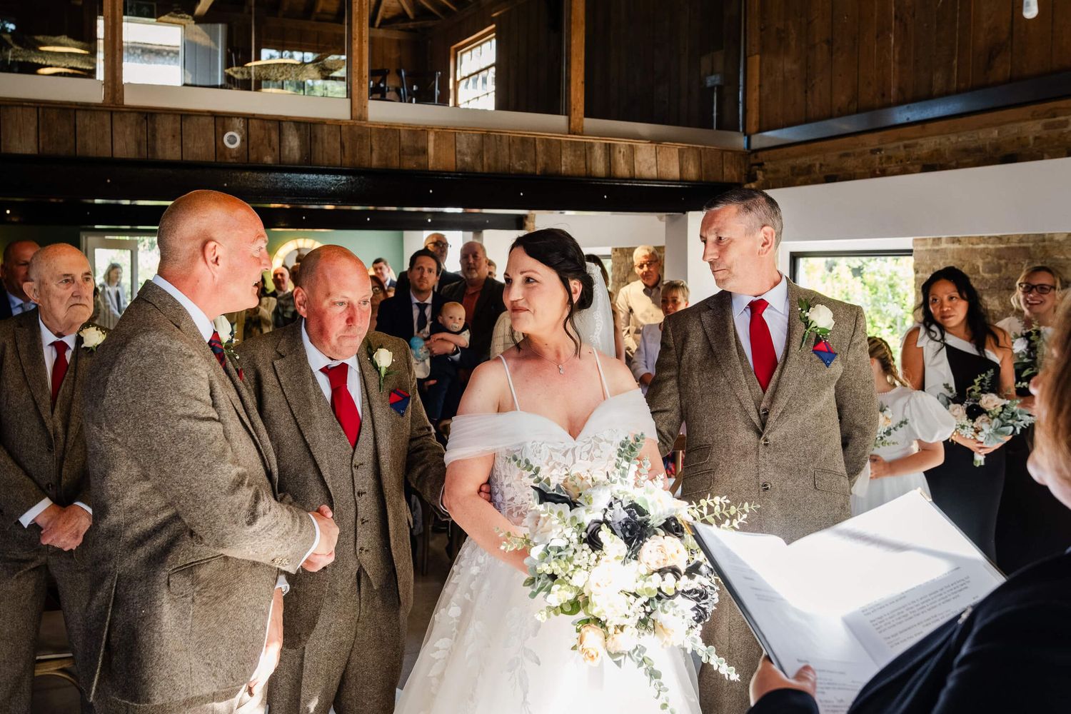 bride at end of aisle with brothers and groom at chapel house