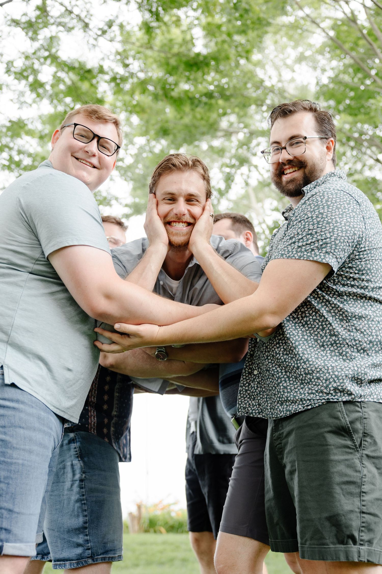 A playful sequence of candid moments between friends embracing and laughing outdoors on a sunny day.