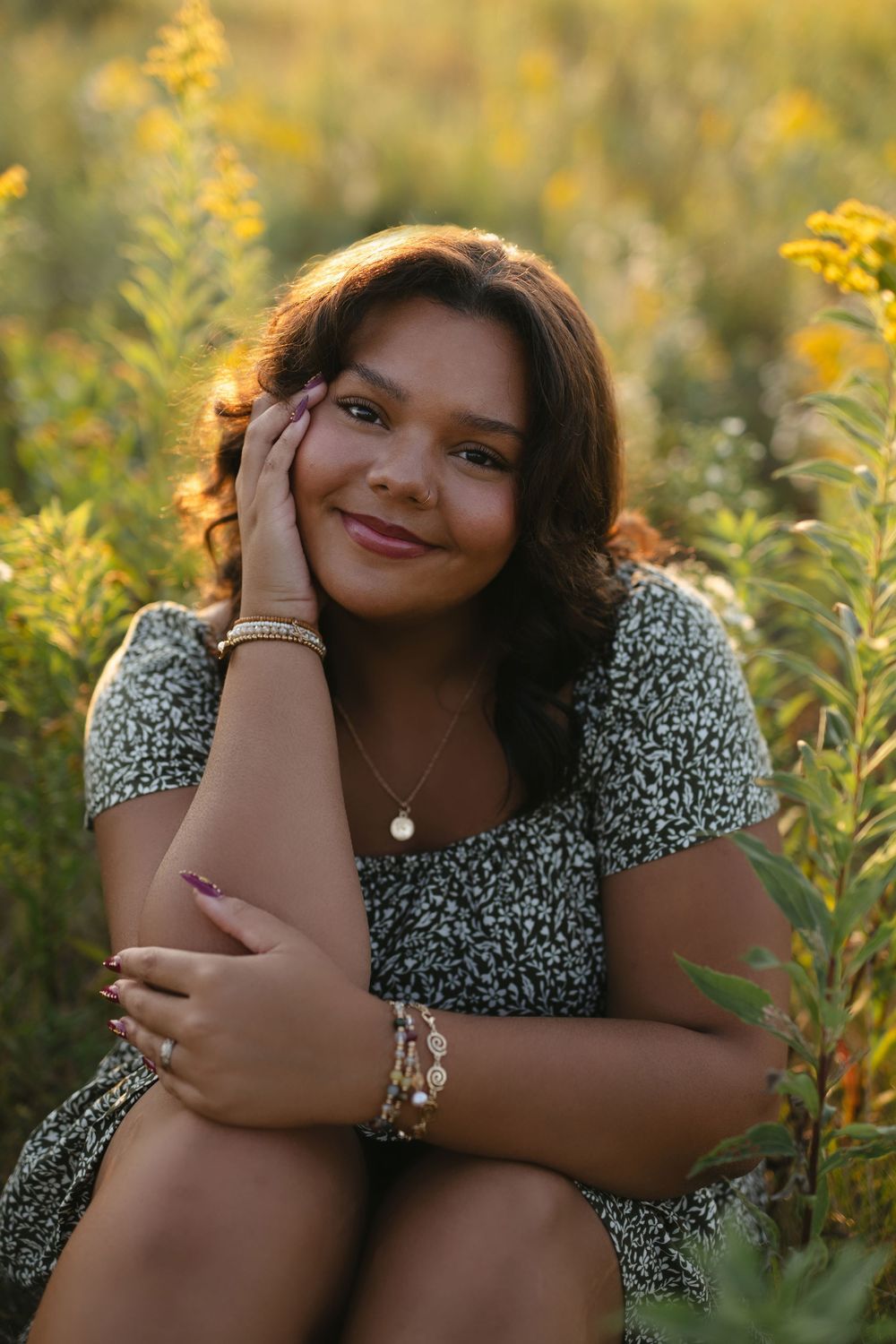A series of outdoor portrait photos in a field of yellow wildflowers at golden hour featuring someone in a floral dress.