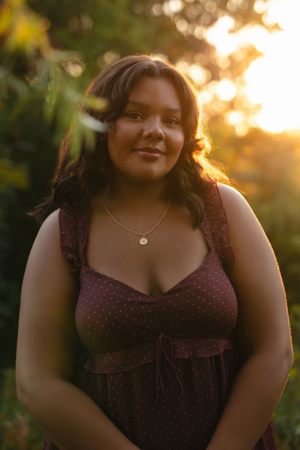 Outdoor portrait series in burgundy dress with golden hour lighting and natural poses.