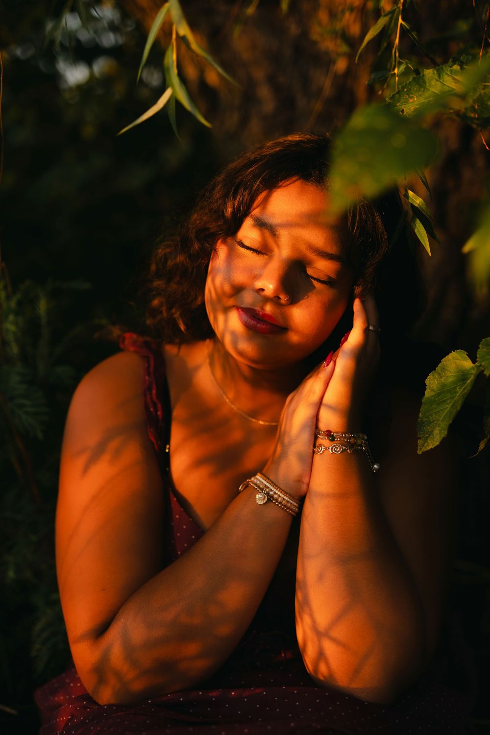 Artistic portrait series captured in warm sunset lighting among lush foliage and natural elements.