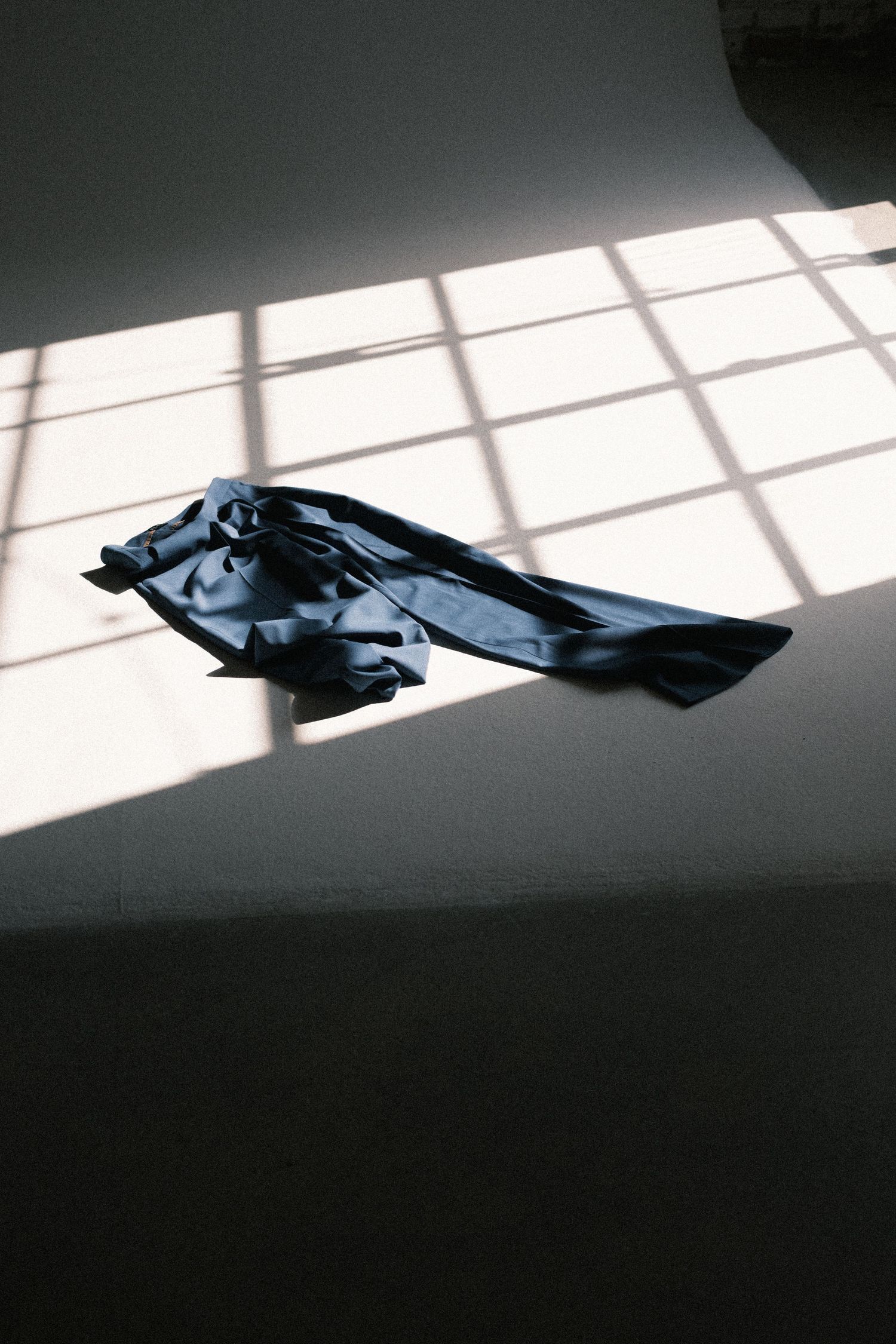 Artistic black and white photograph of shadows cast by window light on a wall with dark geometric shapes.