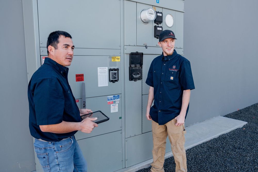 Maintenance technicians inspecting electrical panels in a commercial building.