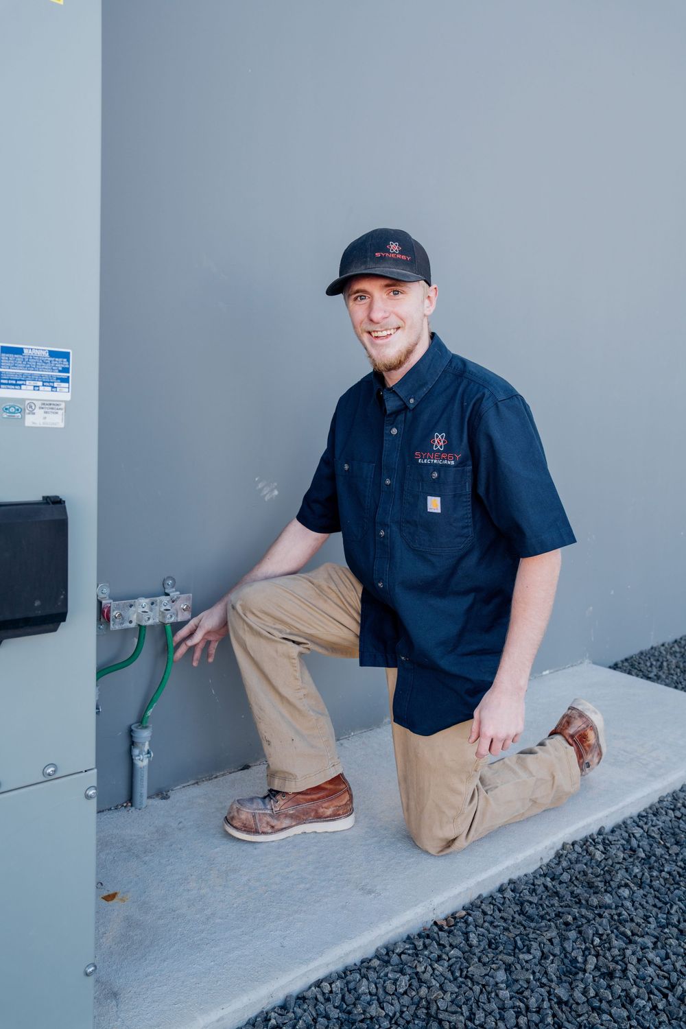 Technicians performing maintenance checks on ground-level electrical systems.