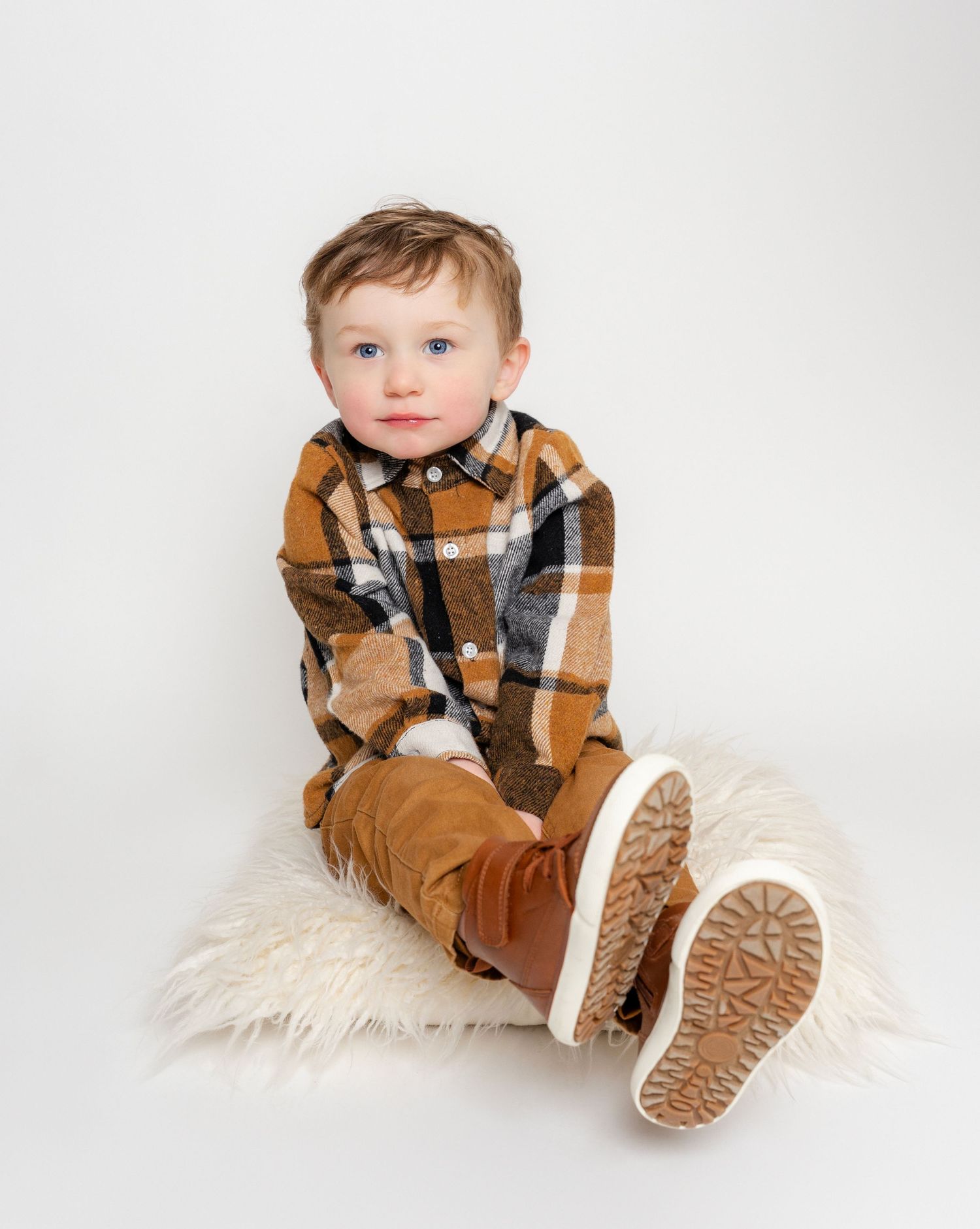 Photo of little boy sitting on a pillow in East Tennessee family portrait photographers studio in Dandridge TN