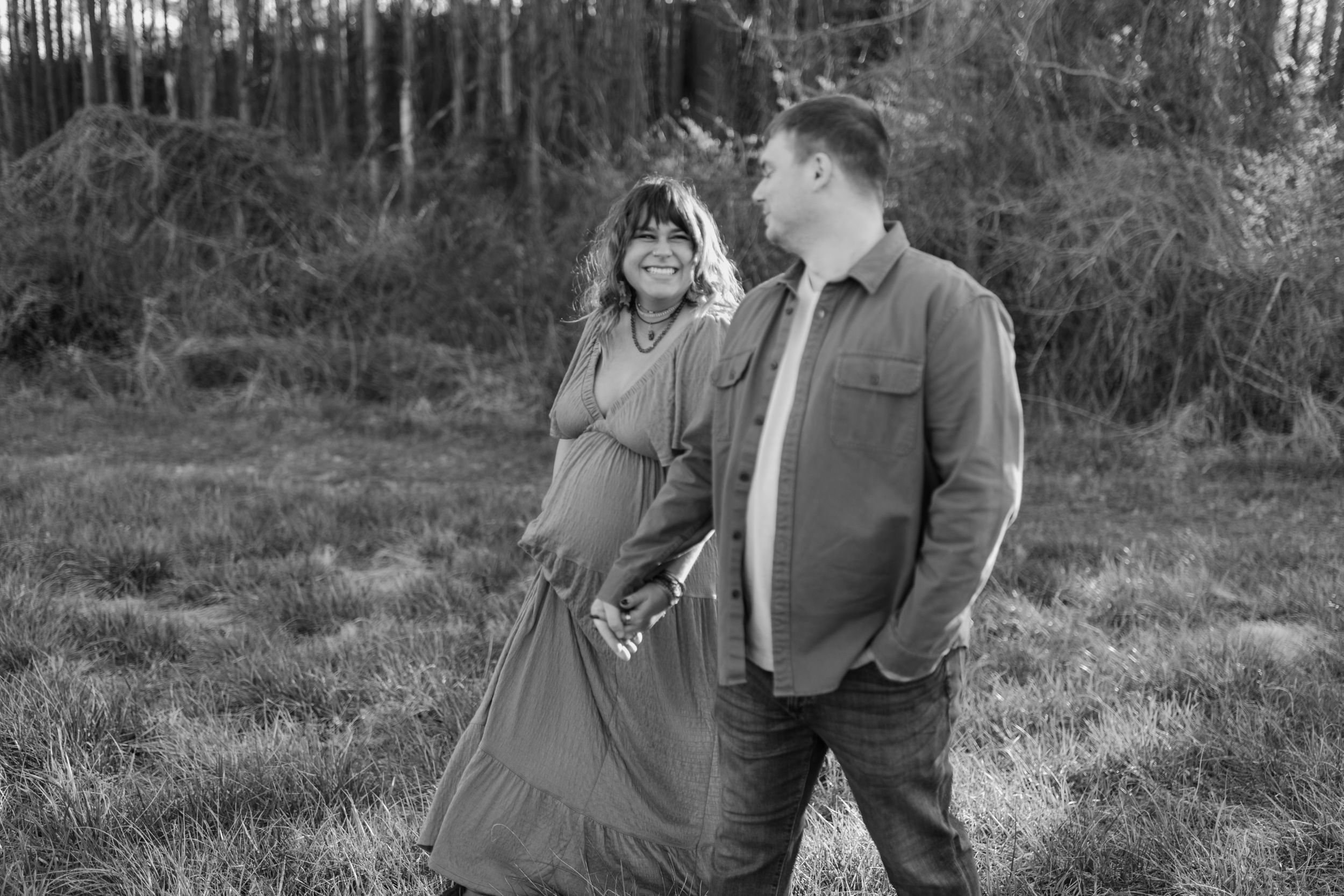 Black and white maternity photo of couple in windy field. Virginia/ North Carolina Maternity Session