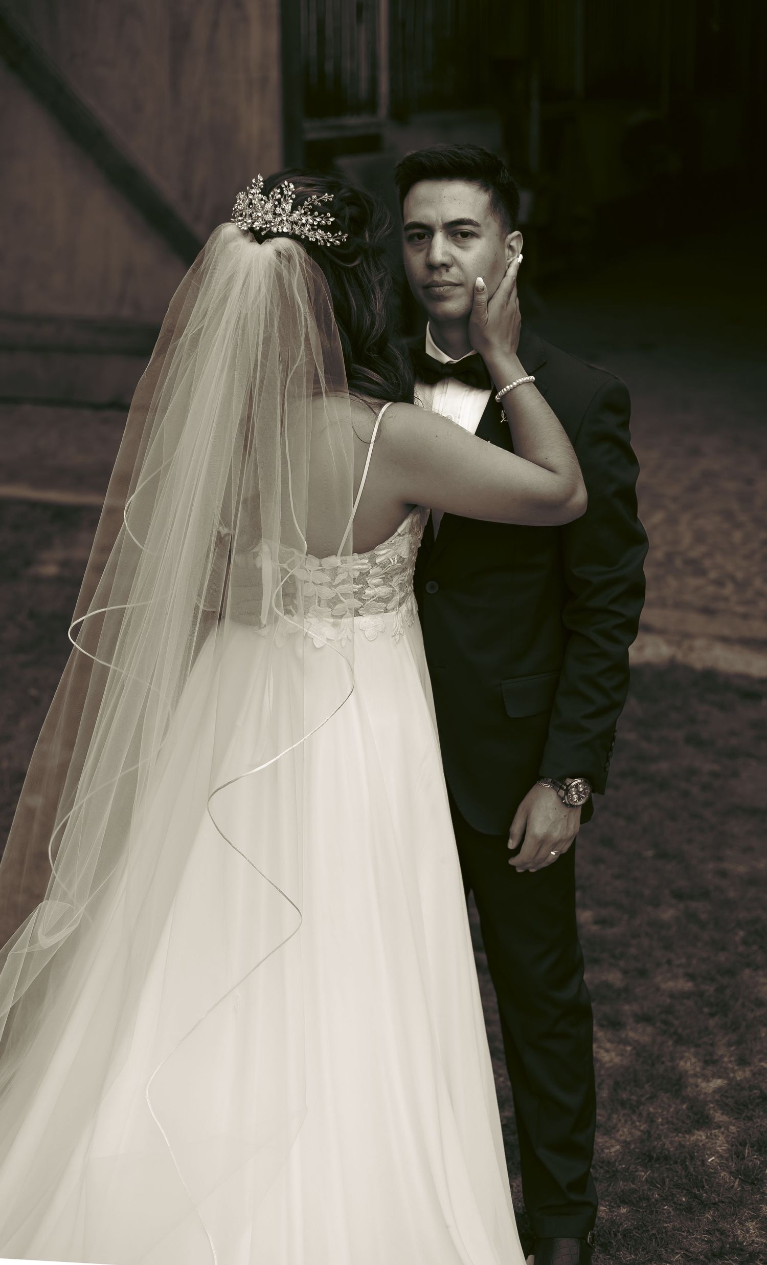 Elegant black and white wedding portrait with flowing veil and formal attire.