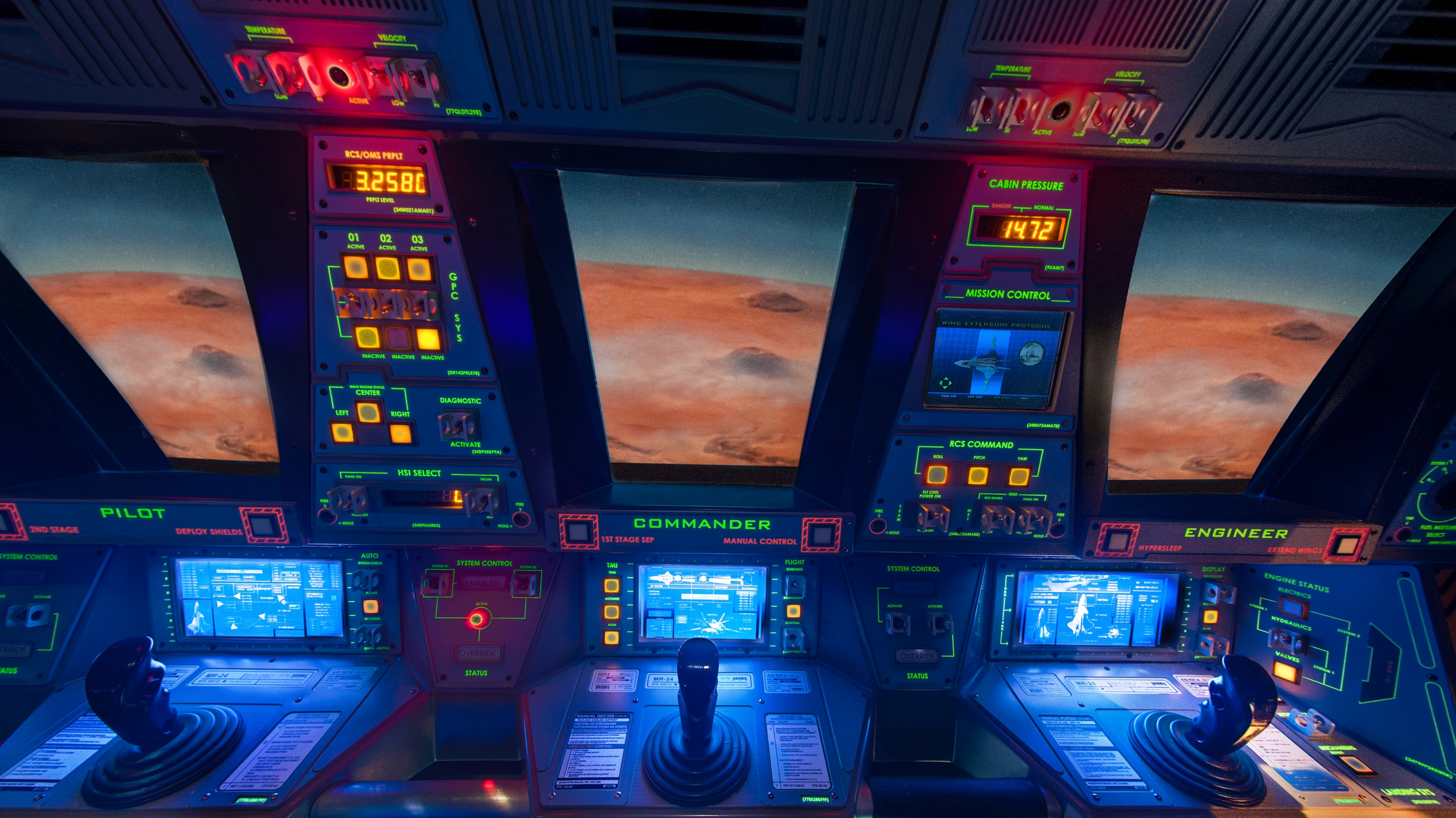 Modern ship bridge control panel illuminated in blue and red lights with digital displays and sunset sky visible through windows.