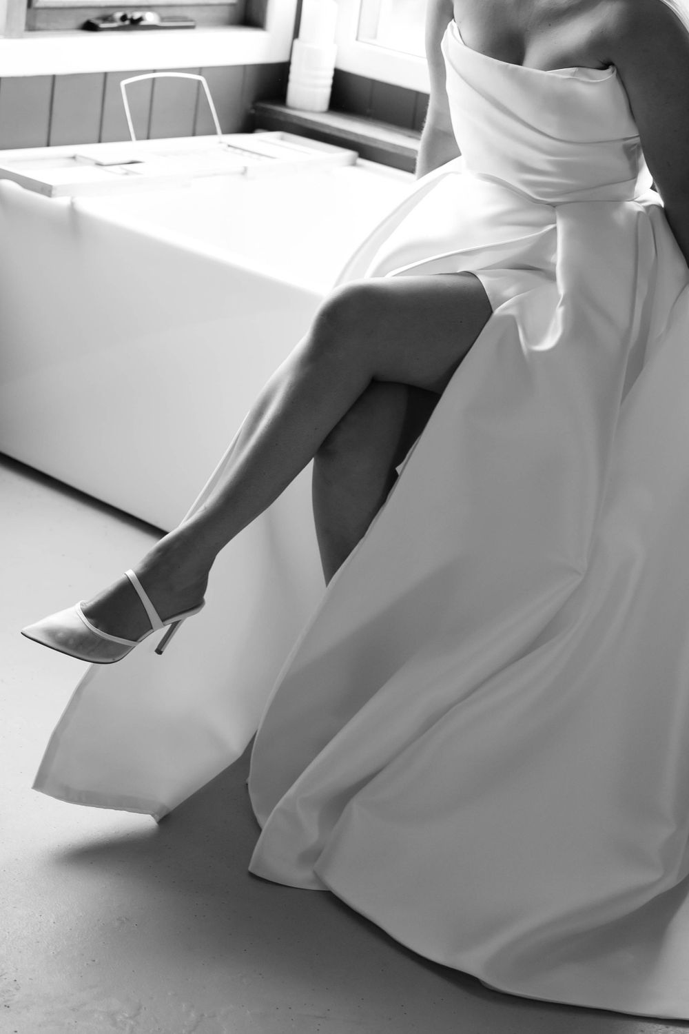 Elegant black and white photo showing details of wedding dress and heels.