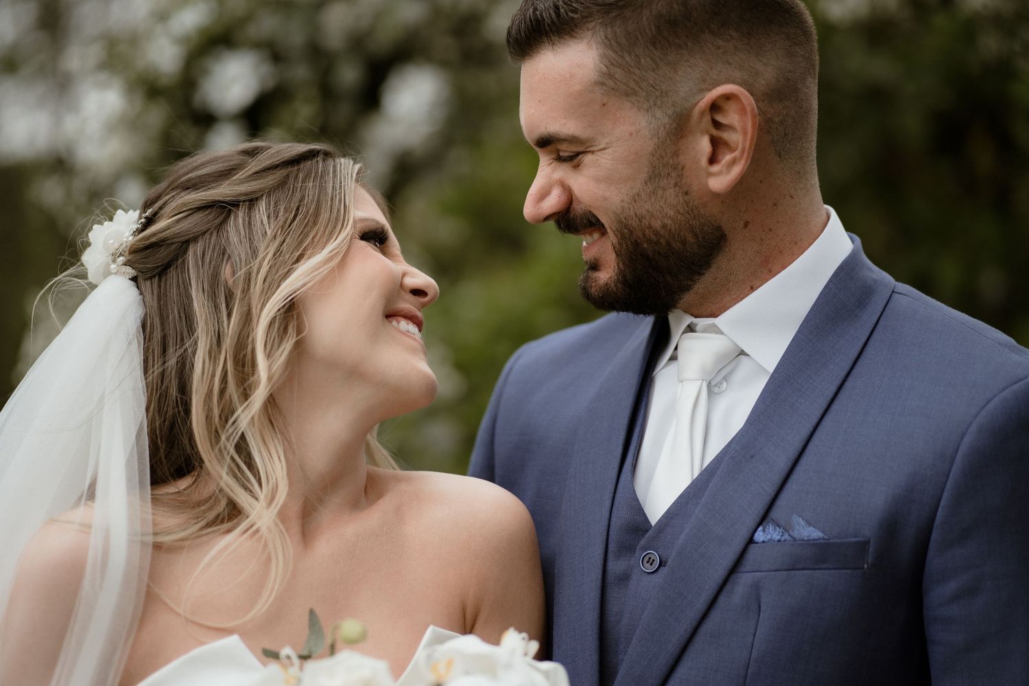 Newlyweds share joyful moments in an outdoor garden setting with natural lighting.