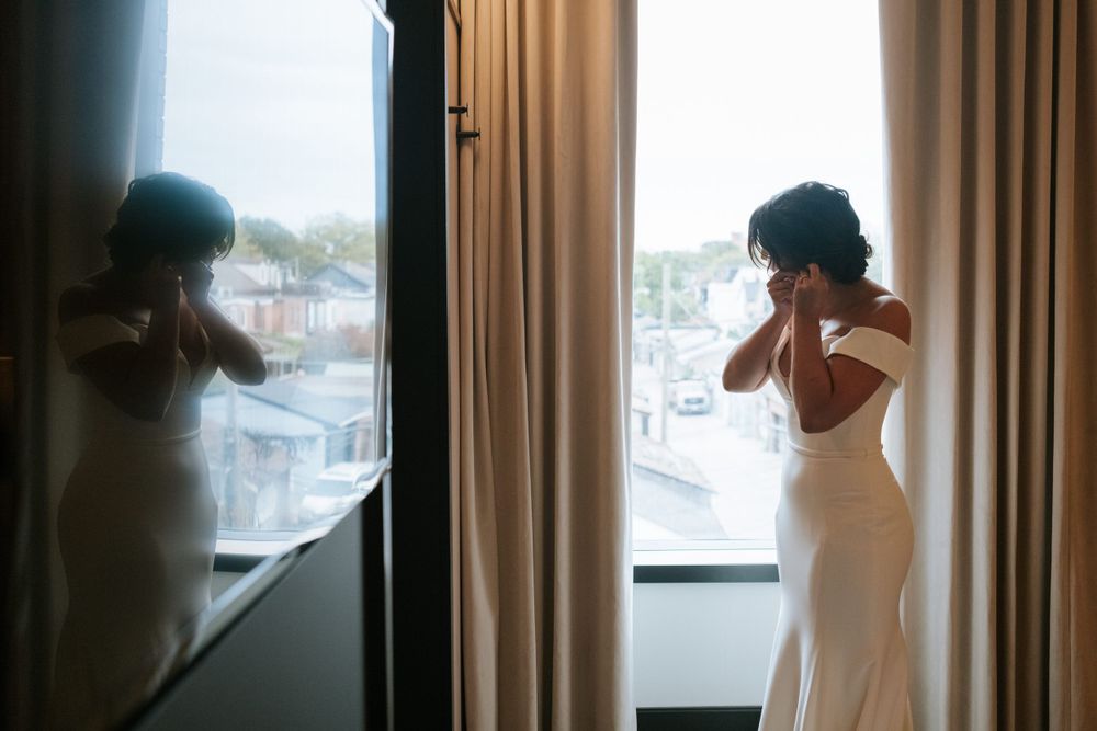 Silhouette of someone in a white dress against window with curtains.