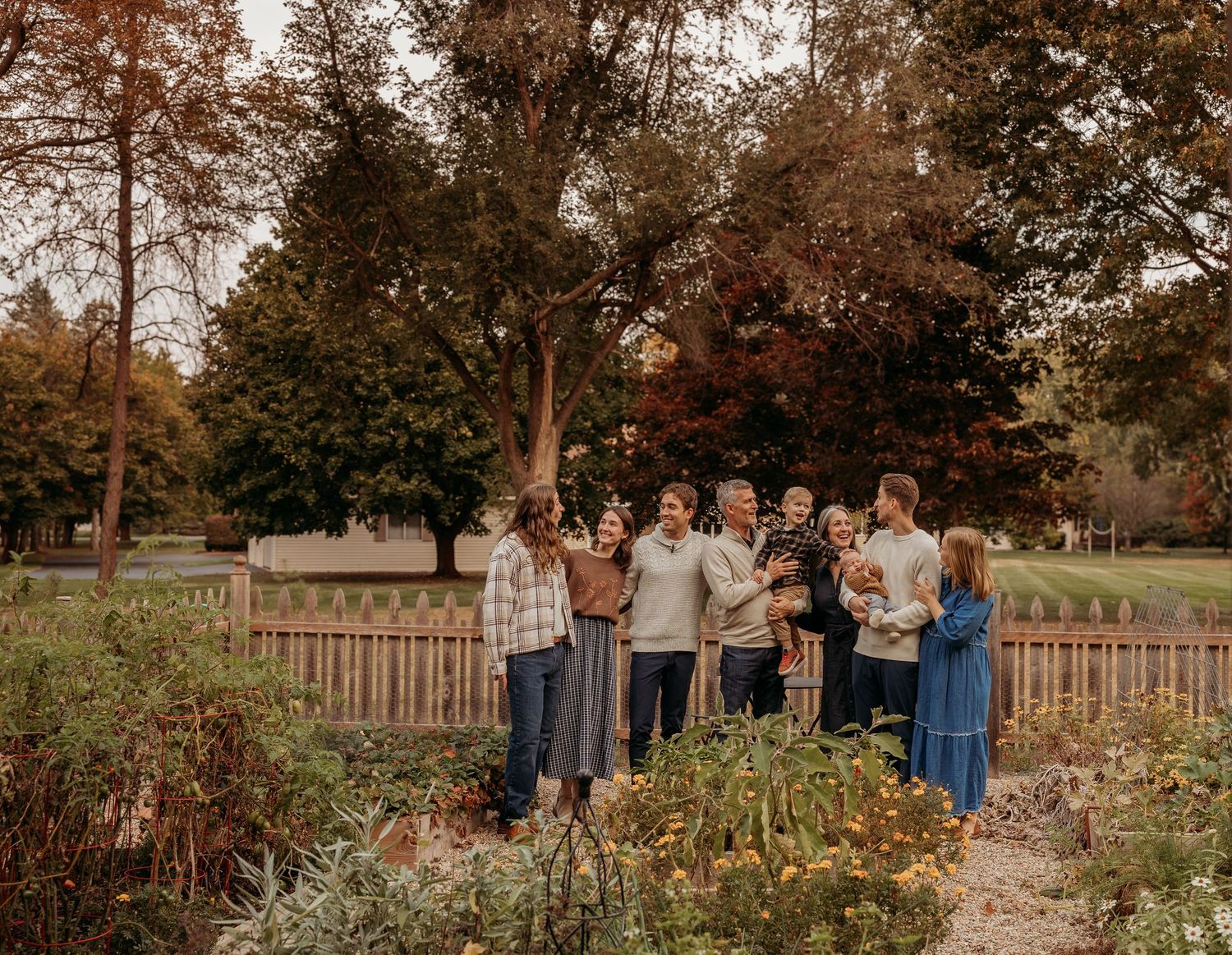 Group gathered in front of white colonial style building entrance with arched doorway.