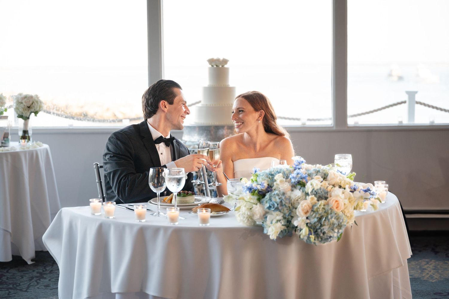 A romantic wedding ceremony under a floral arch with blush pink roses and greenery.
