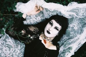 A femme lies on a white lace shawl.