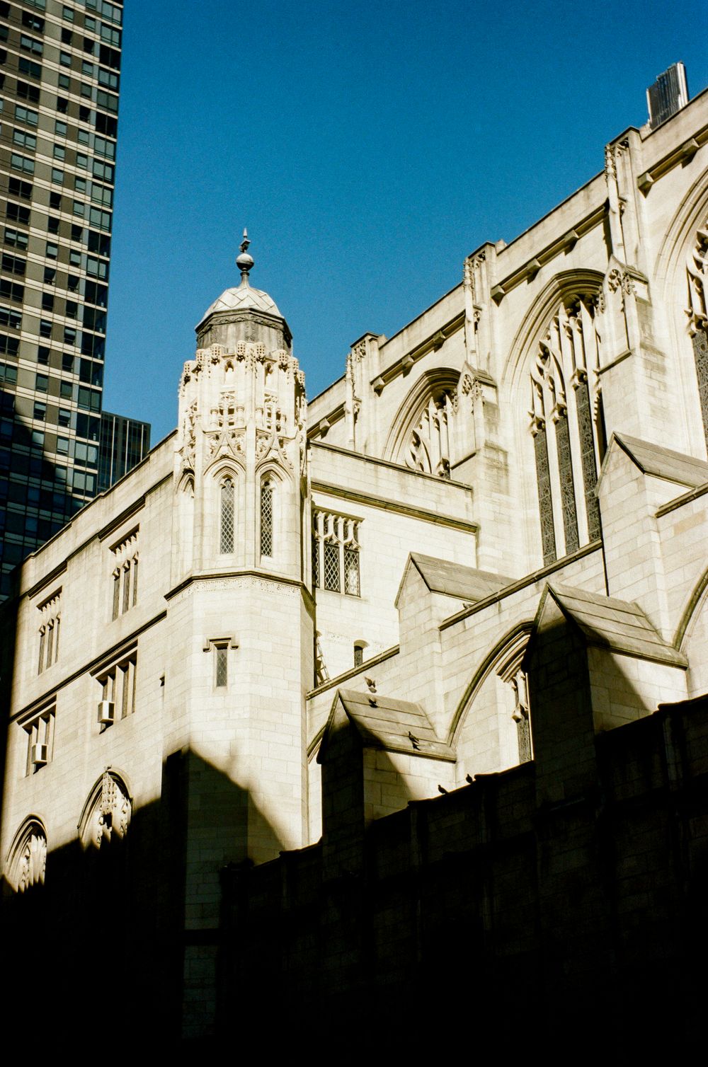 Gothic church architecture with white stone facade and ornate spires against blue sky.