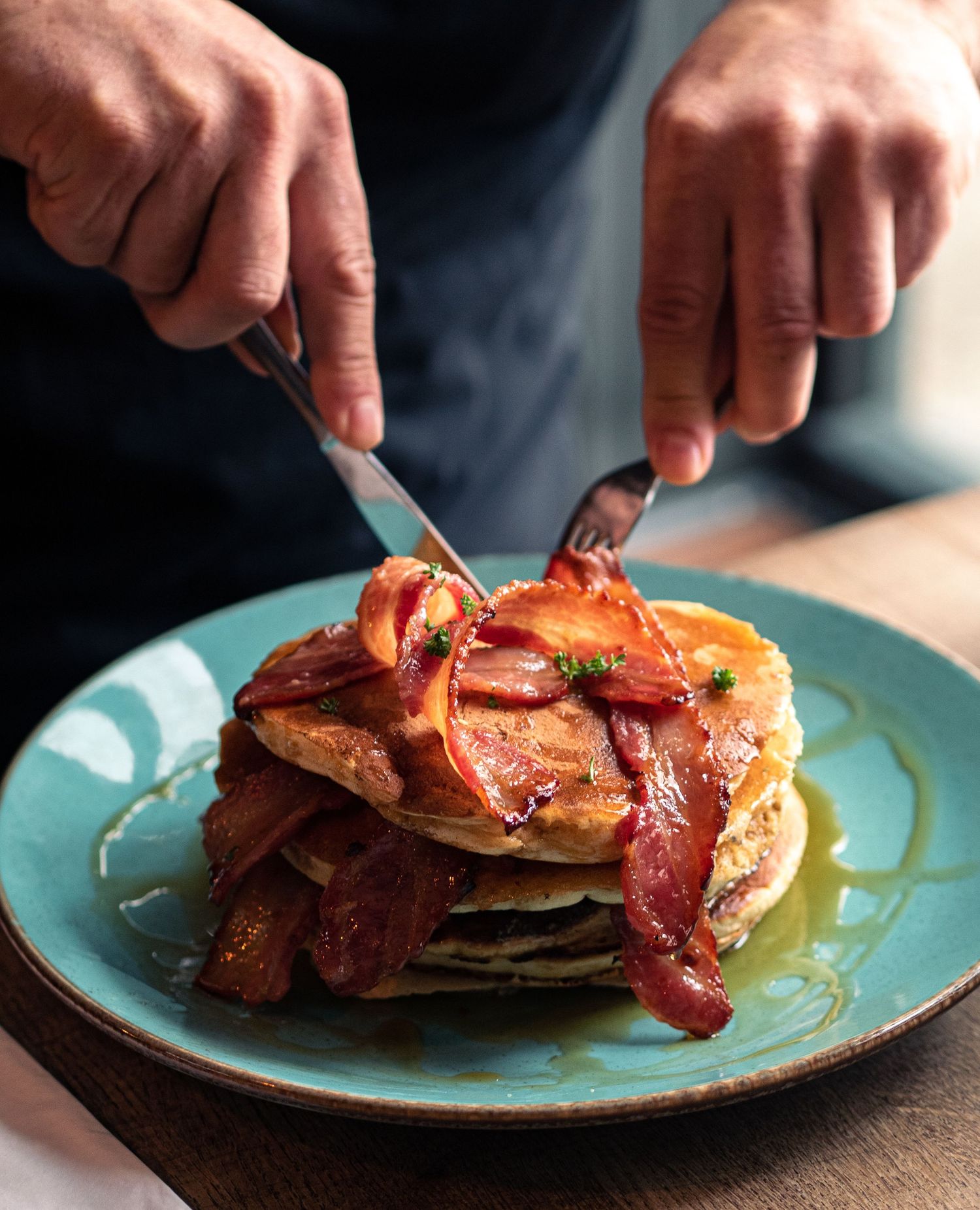 restaurant website photography of hands cutting pancakes